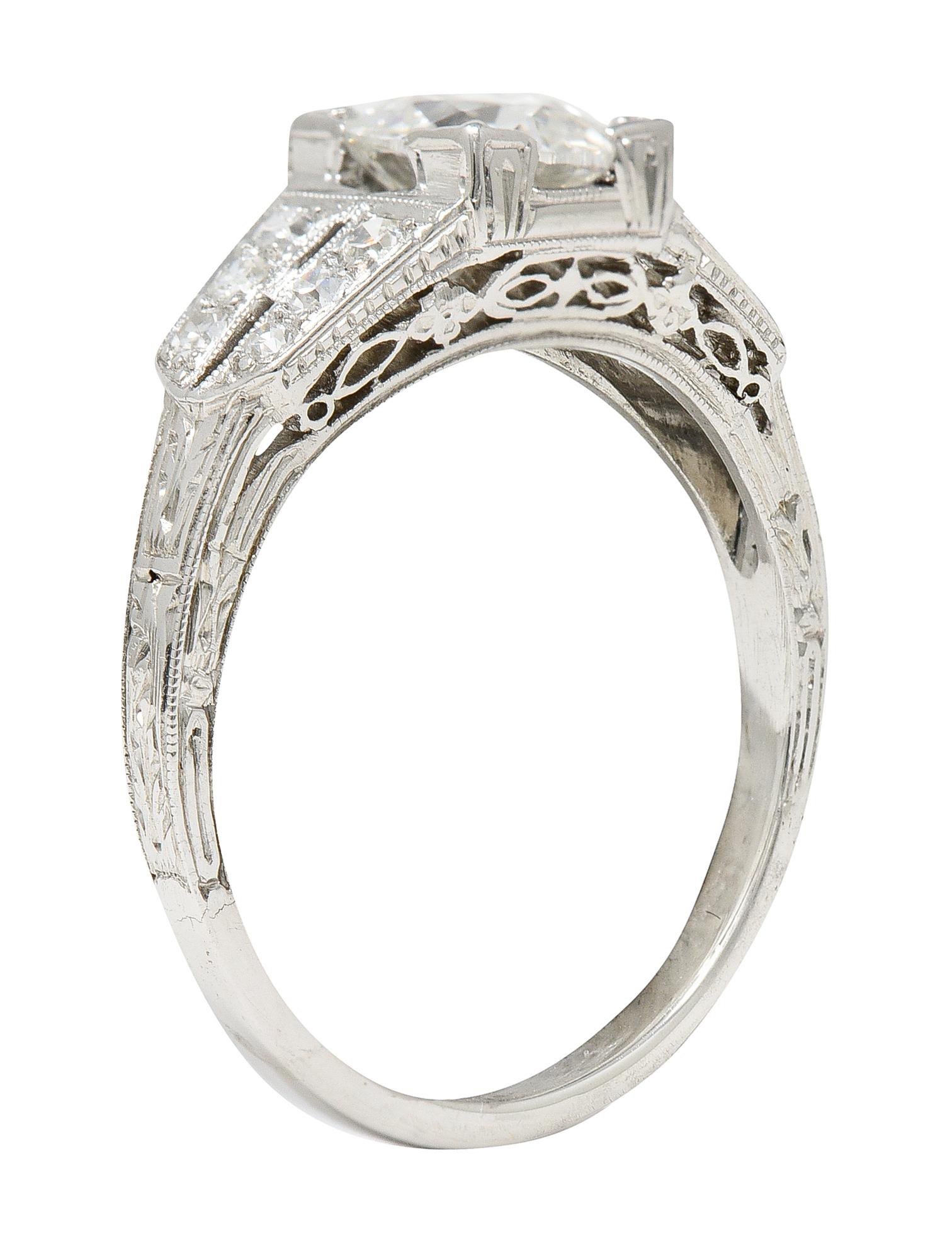 Ring centers a 0.96 carat old European cut diamond - H in color with S12 clarity. Set in an engraved square form head and flanked by bead set single cut diamonds. Weighing approximately 0.18 carat total - eye clean and bright. Accented by engraved