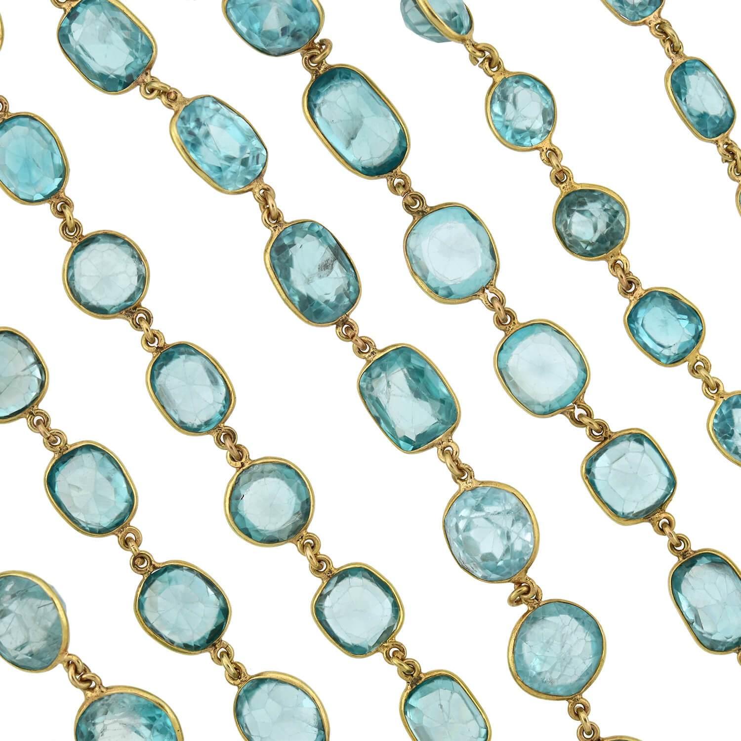 An absolutely exquisite blue zircon necklace from the Art Deco (ca1920s) era! Crafted in 14kt yellow gold, this stunning piece adorns 92 natural blue zircon stones, each separated by a delicate chain link. The sparkling stones graduate slightly in