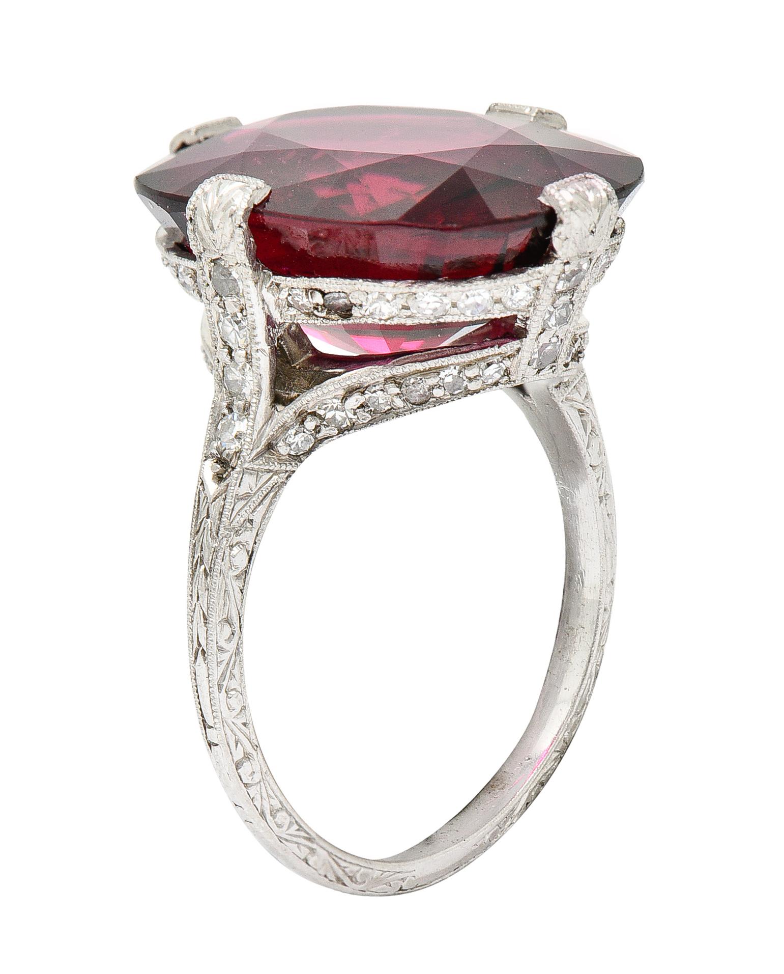Featuring a cushion cut rubellite tourmaline weighing 10.96 carats. Eye clean and red to strongly purplish red in color with strong saturation. Basket set by wide and stylized prongs accented by single cut diamonds. Weighing collectively