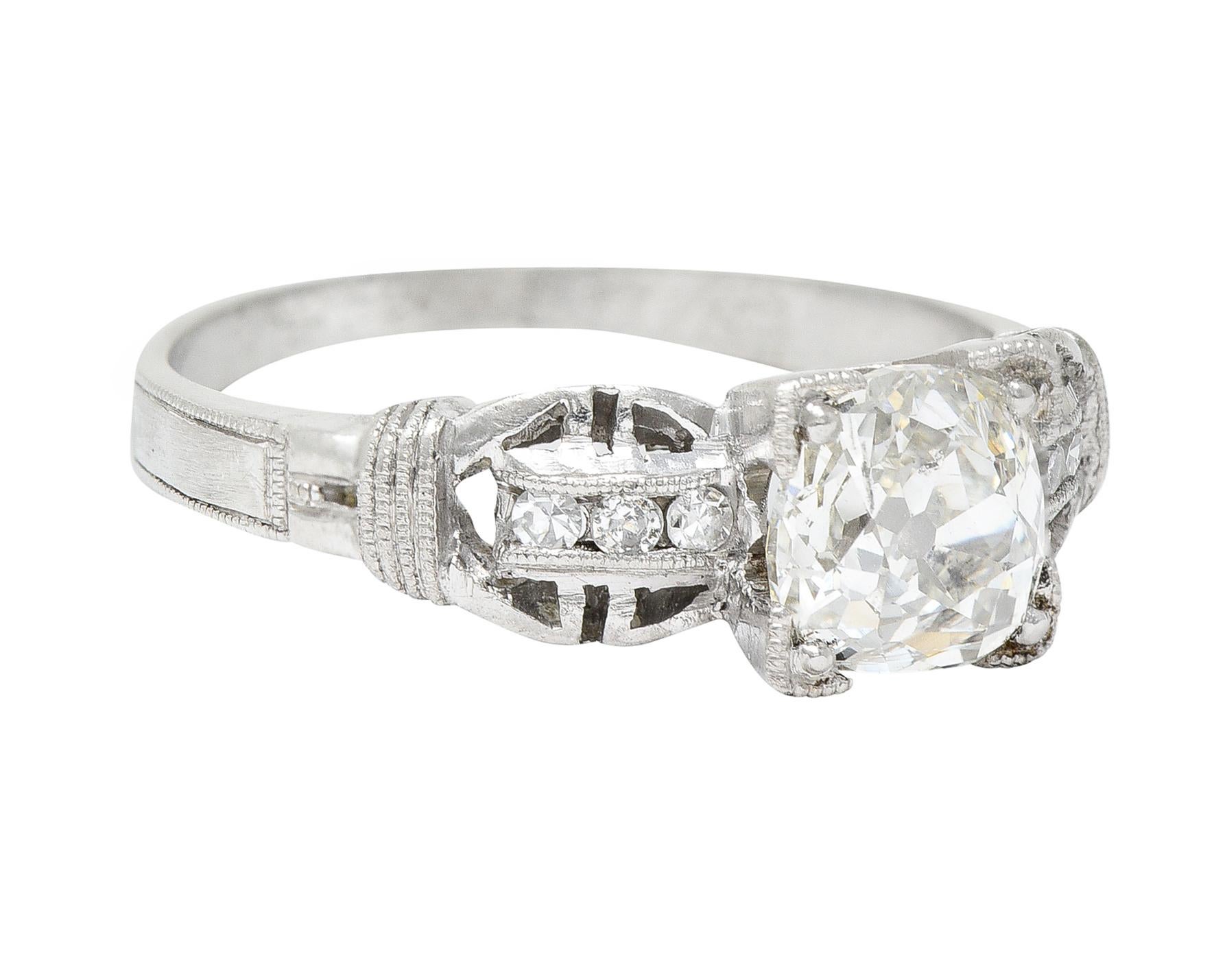 Featuring an old mine cut diamond weighing 1.06 carats - J color with SI2 clarity

Set in a stylized square form head and flanked by buckle motif shoulders

Accented by single cut diamonds weighing approximately 0.10 carat - eye clean and