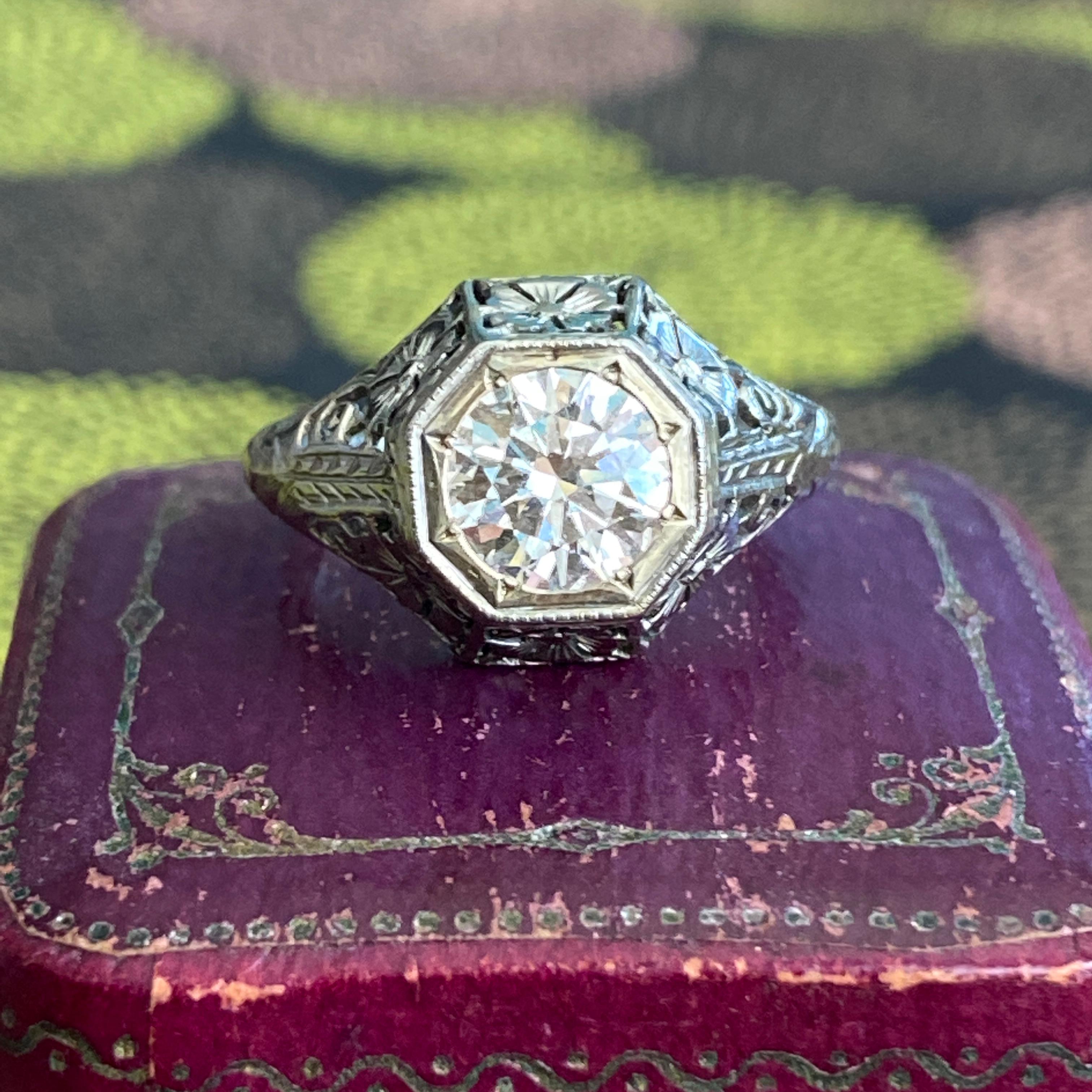 Details:
Stunning Art Deco 1.18ct diamond ring, with sweet floral pansy filigree in 18K white gold. This ring is from the 1920's, and is in very good condition. The shoulders of the ring have pansy flowers, and delicate filigree scroll work, as well