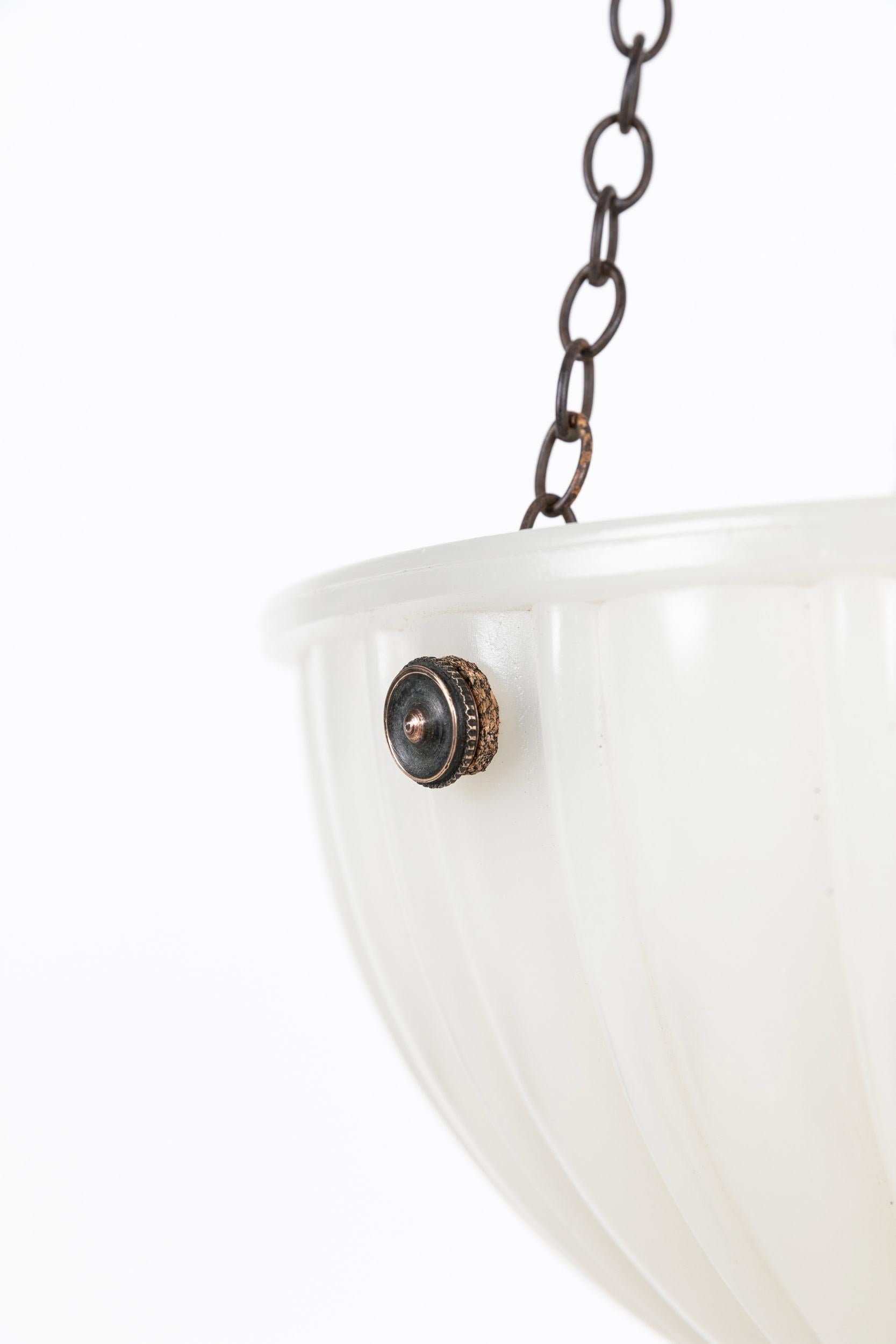 

A pressed glass moonstone plafonnier bowl pendant light. c.1930

Heavy duty pressed milk glass of fluted design, supported by integral hooks and ceiling plate. Chains could be shortened to suit drop.

Rewired with black twisted flex.
