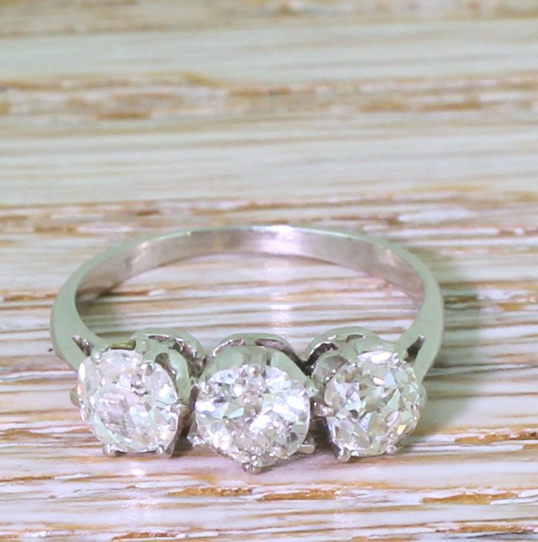 A supremely lovely vintage three stone diamond ring. Set with a trio of old cuts of matching sizes in six claw coronet collets, leading to a slim D-shaped white gold shank. Beautifully balanced and super-wearable.

Cut – Old mine cuts.

Colour – G