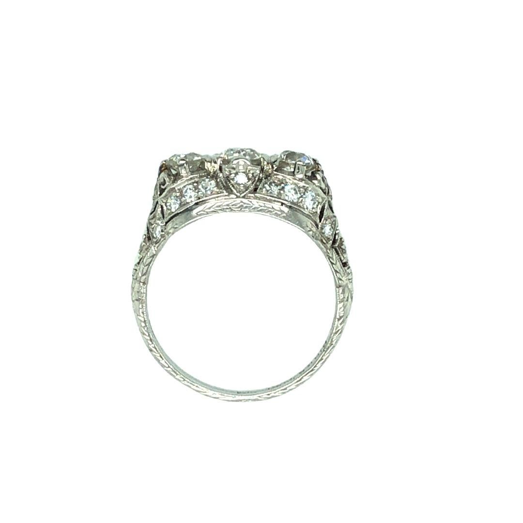 This sumptuous Art Deco diamond ring is a true masterpiece, expertly crafted to highlight three sparkling European cut diamonds. The diamonds are of exceptional quality, graded G color and VS clarity, with a total weight of approximately 1 carat.