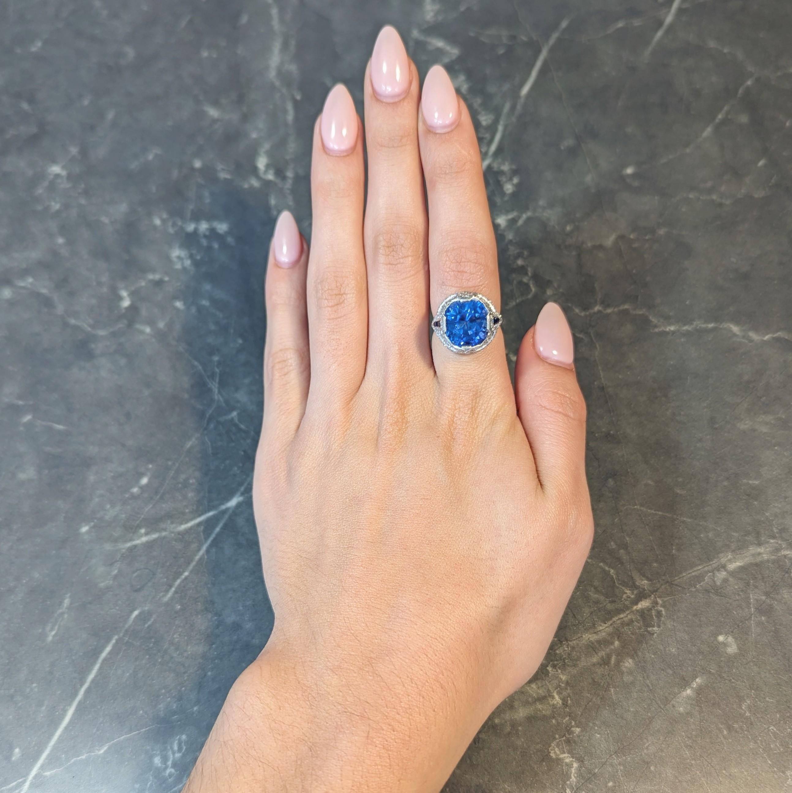 In der Mitte ein Saphir im Kissenschliff mit einem Gesamtgewicht von 10,96 Karat - transparent und von leuchtend blauer Farbe
Natürlicher srilankischer Ursprung ohne Anzeichen einer Wärmebehandlung - mit laschenförmigen Zacken besetzt 
Mit einer