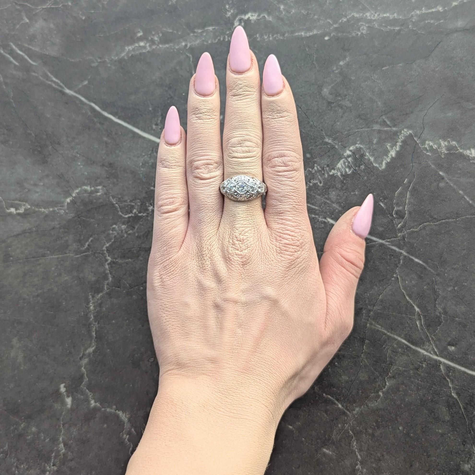 Cinq diamants de taille européenne ancienne sont sertis d'est en ouest dans des têtes de forme octogonale.
D'un poids total d'environ 1,01 carat - Couleur G/H et pureté VS2
Avec une galerie en forme de bombé à motif de volutes percées.
Accentué par
