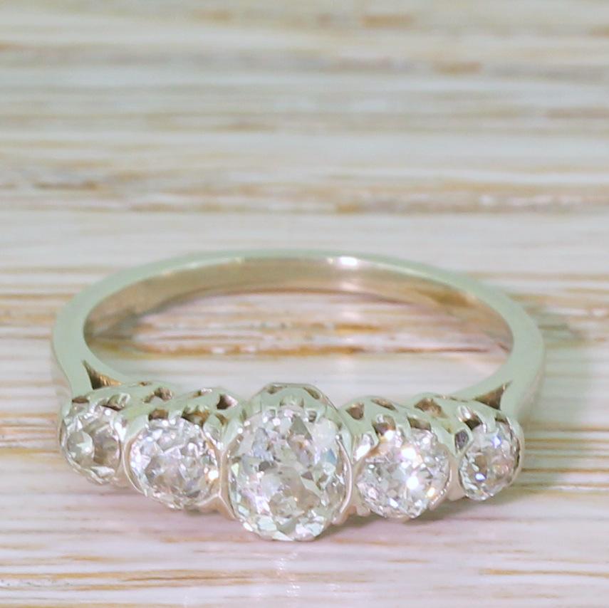 A exquisitely balanced vintage five stone ring. The graduating line of old cut diamonds are high white, bright and impressively lively. Each diamond is secured in fine coronet collets with fine (almost semi-rubover) claws between in each stone,