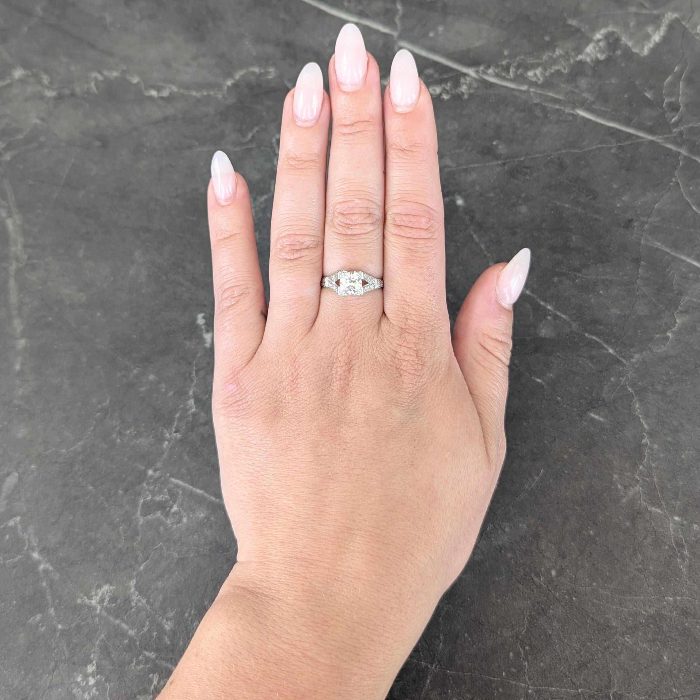 Centering an old European cut diamond weighing approximately 1.00 carat - H color with VS2 clarity
Set with tri-beads in a square form head with a pierced diamond shaped profile with fanning flourish
Flanked by split shoulders bead set with rows of
