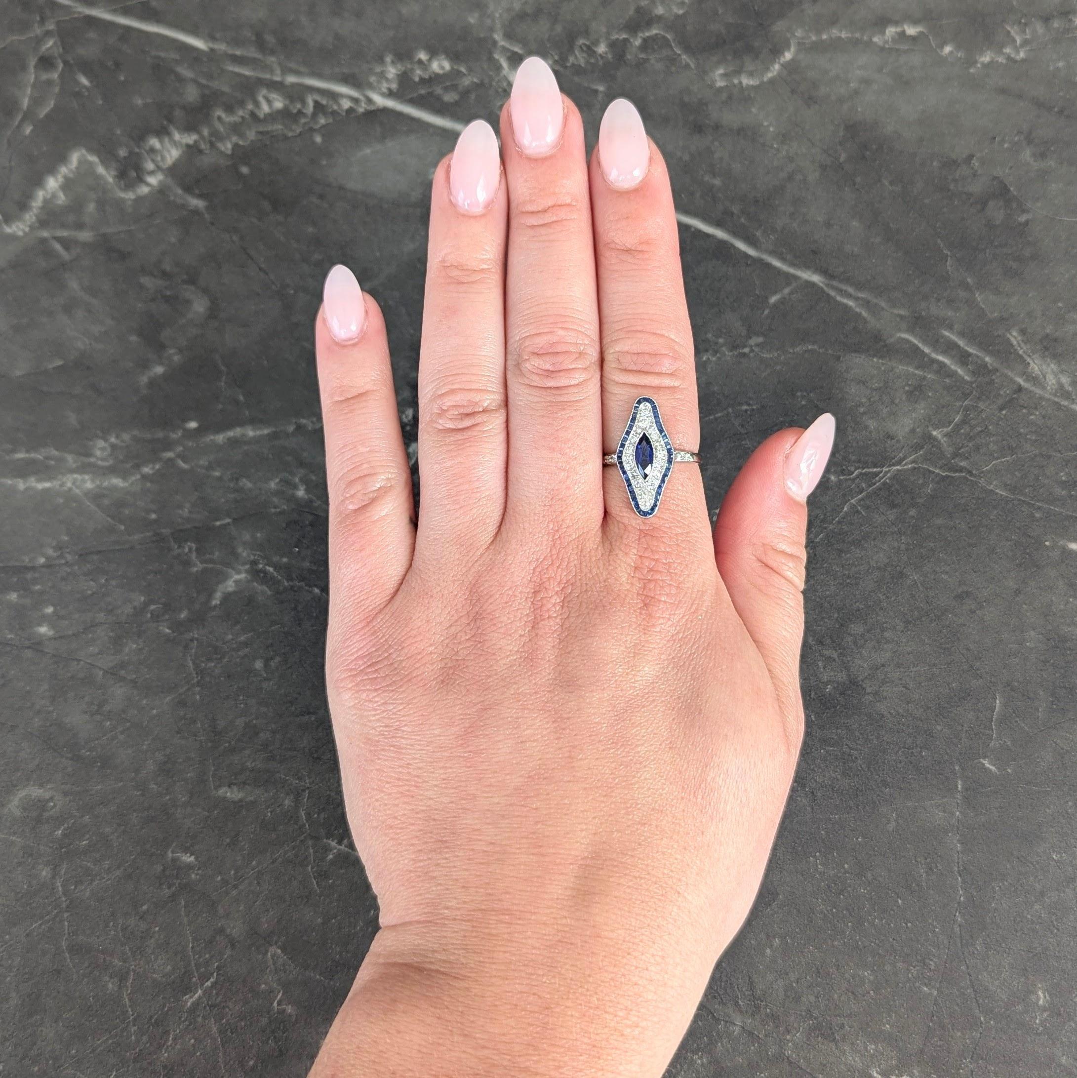 In der Mitte ein marquise geschliffener Saphir mit einem Gewicht von ca. 0,44 Karat - transparente mittelblaue Farbe
Eingefasst in eine gefräste Lünette mit einem doppelten Halo, umgeben von Diamanten im Einzelschliff und Saphiren im