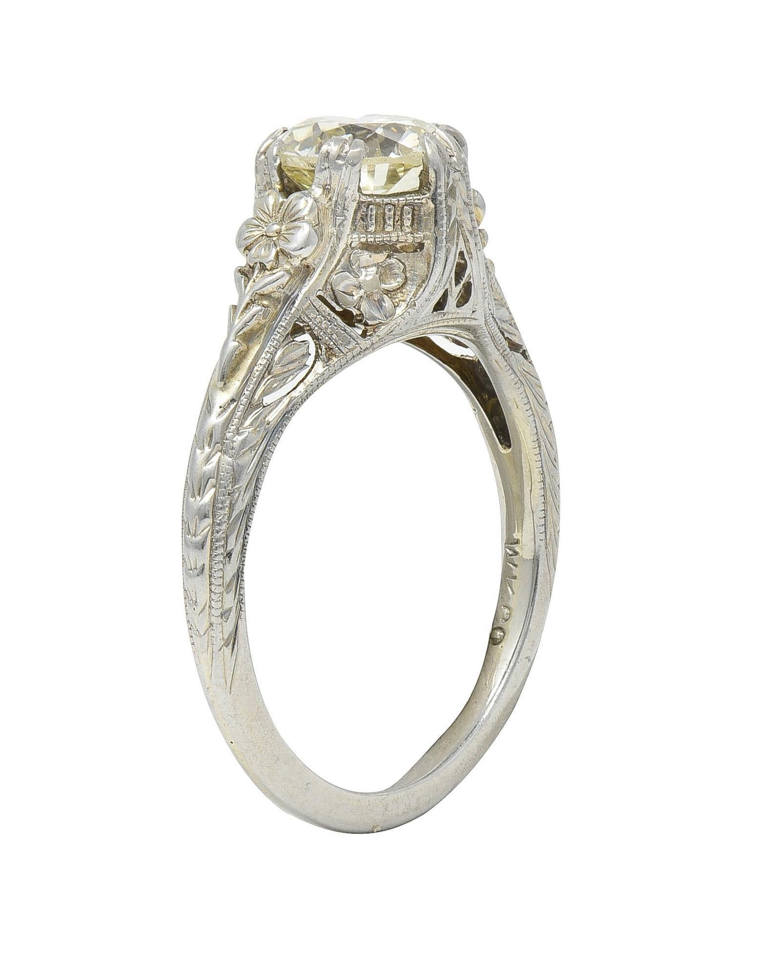 Centering an old European cut diamond weighing 1.31 carats - Q-R color with VS clarity
Set with split prongs with an ornately decorated and pierced gallery 
Featuring raised orange blossom motifs and wheat motif engraving
Accented by grooved details