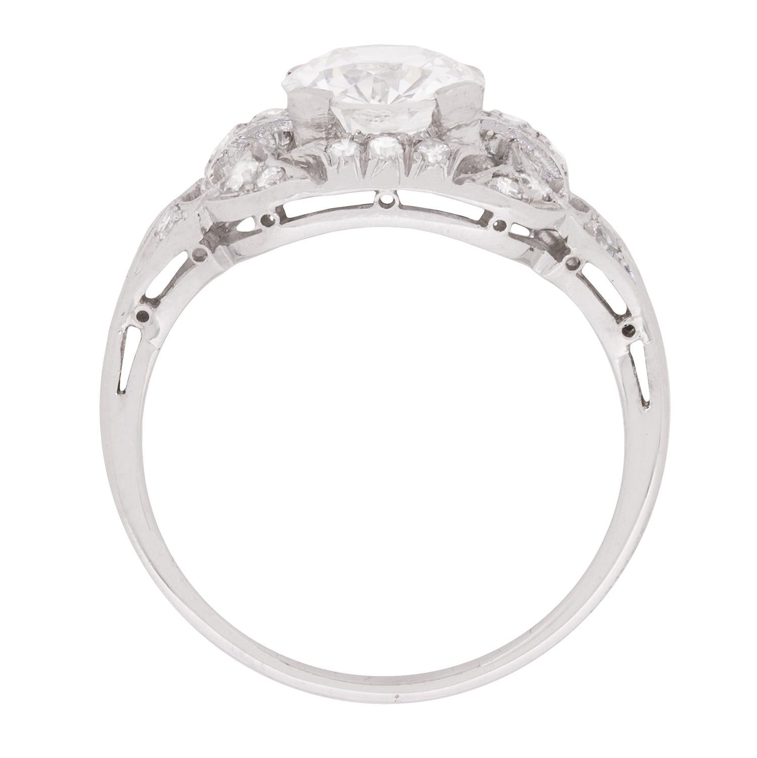 This beautiful engagement ring features a centre diamond within a four claw setting. The stunning stone has a weight of 1.35 carat and is a G in colour and SI1 in clarity, high quality for the art deco period from which it dates. Surrounding the