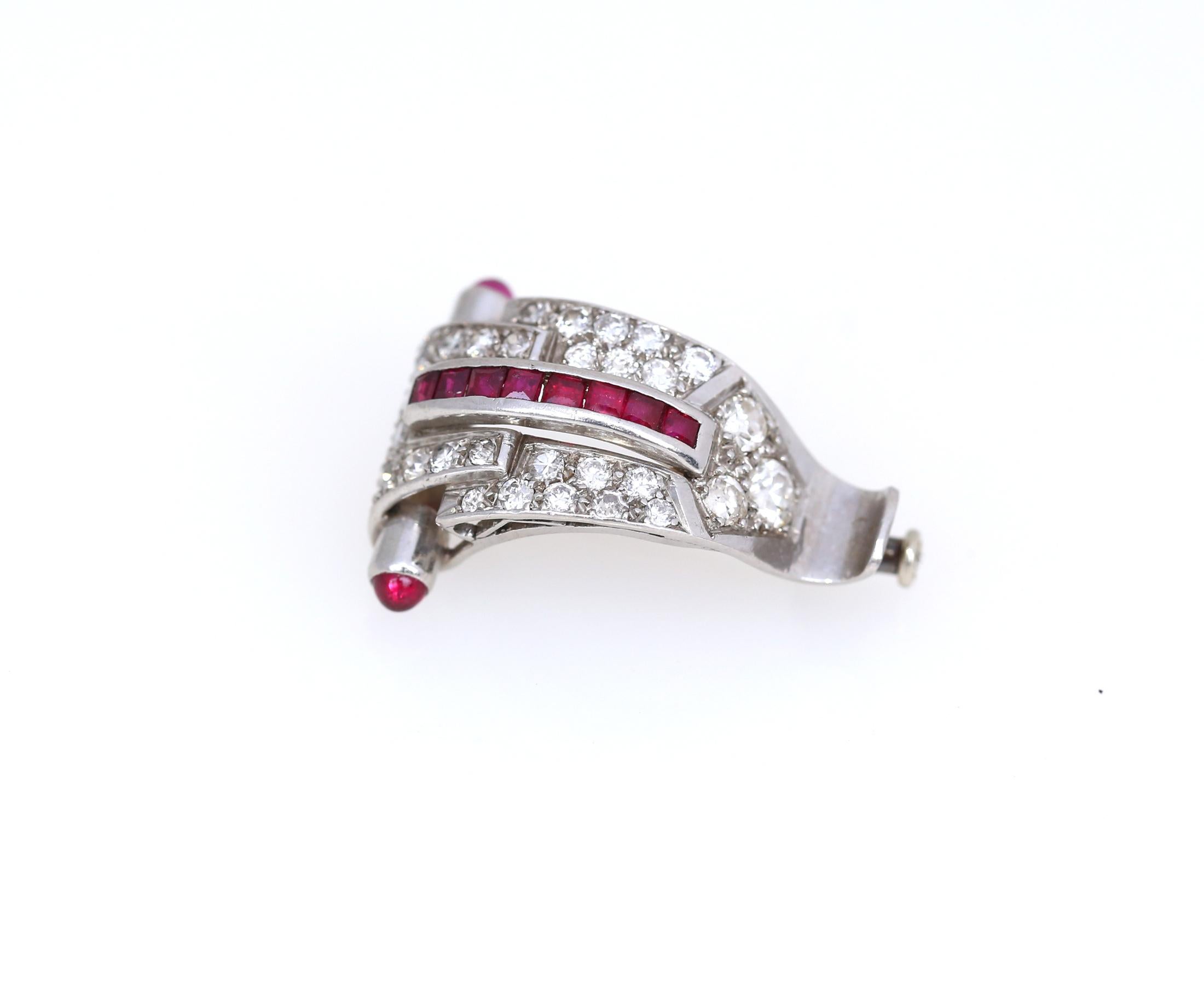 Art Deco Platinum Diamond 1.35 Carat Rubi Brooch, 1920

A superb example of the Art Deco style, in many ways. It's the red line on Rubies, it is in the wave shape of the brooch itself and in amazing red dot touch of the cabochon Rubes on the sides. 