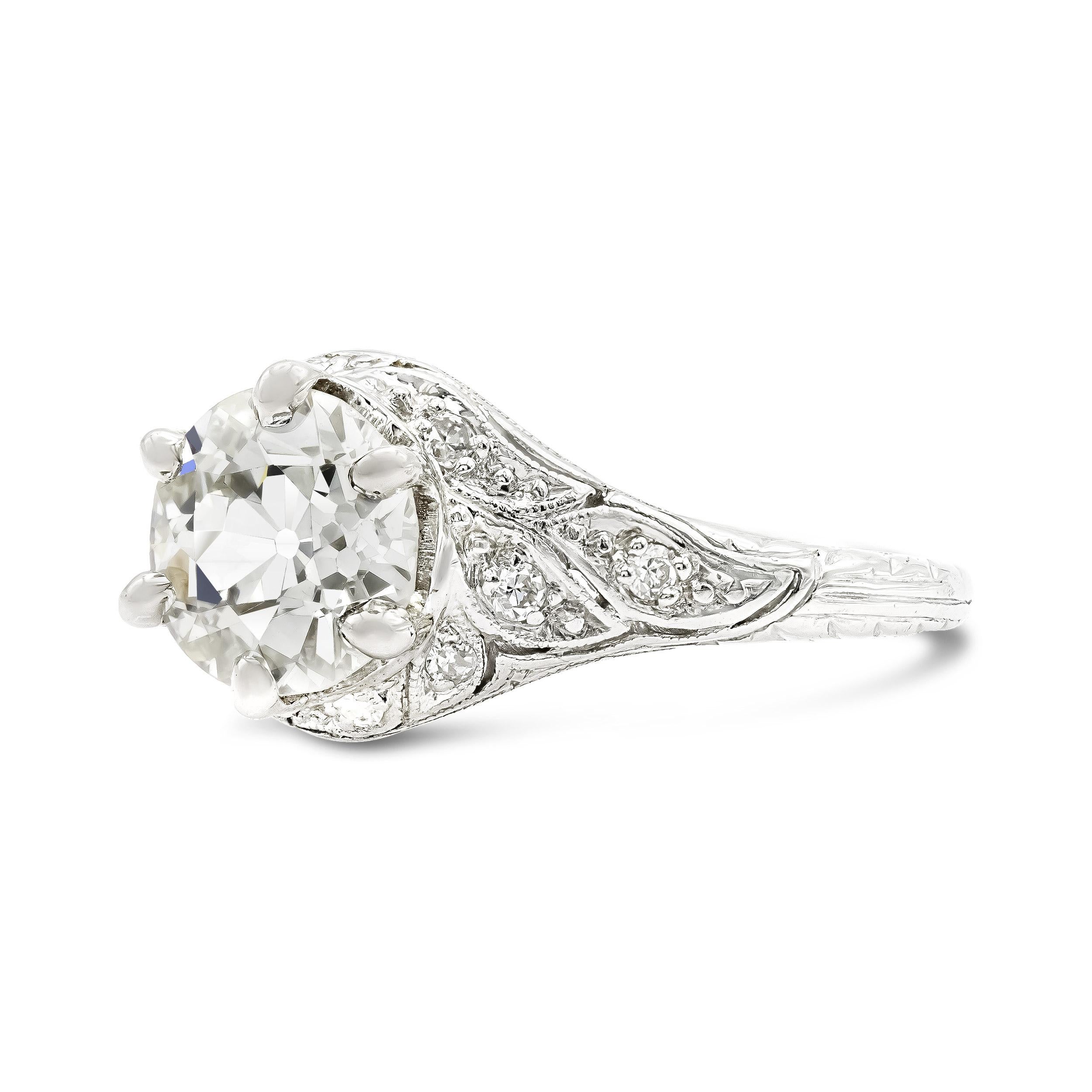 There is nothing like the delicate craftsmanship present in art deco era engagement rings. This antique setting has all the old world charm we love. A 1.35 carat old European cut diamond centers in a six prong basket, its open culet and flickering