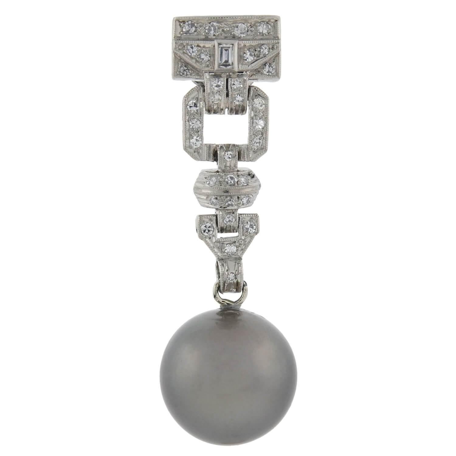 A stunning pair of diamond and black Tahitian pearl earrings from the Art Deco (ca1920) era! Crafted in platinum, each earring adorns a single Tahitian South Sea pearl dangling at the base of an elegant drop design. The 13.5mm pearl exhibits a high