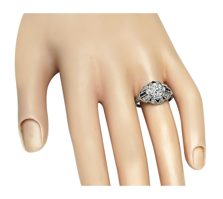 This is an elegant platinum engagement ring from the Art Deco era. The ring is centered with sparkling old European cut diamond that weighs approximately 1.39ct. The color of the diamond is I with VS clarity. The center diamond is accentuated by