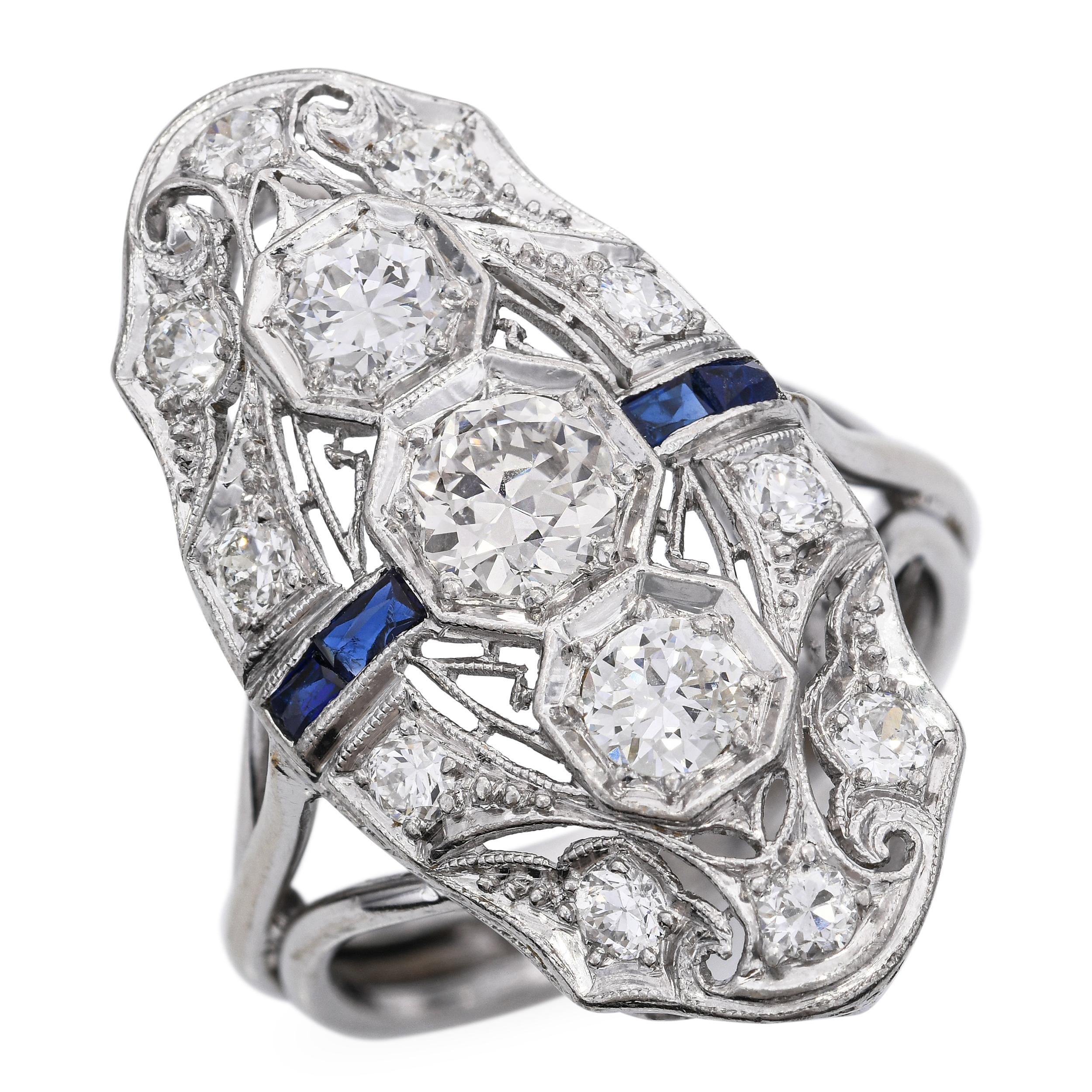 Este elegante anillo de cena Art Decó está elaborado en una combinación de oro blanco de 13 quilates y platino, y luce un total de 1,33 quilates de brillantes diamantes. El diseño presenta una audaz disposición central de diamantes, acentuada por