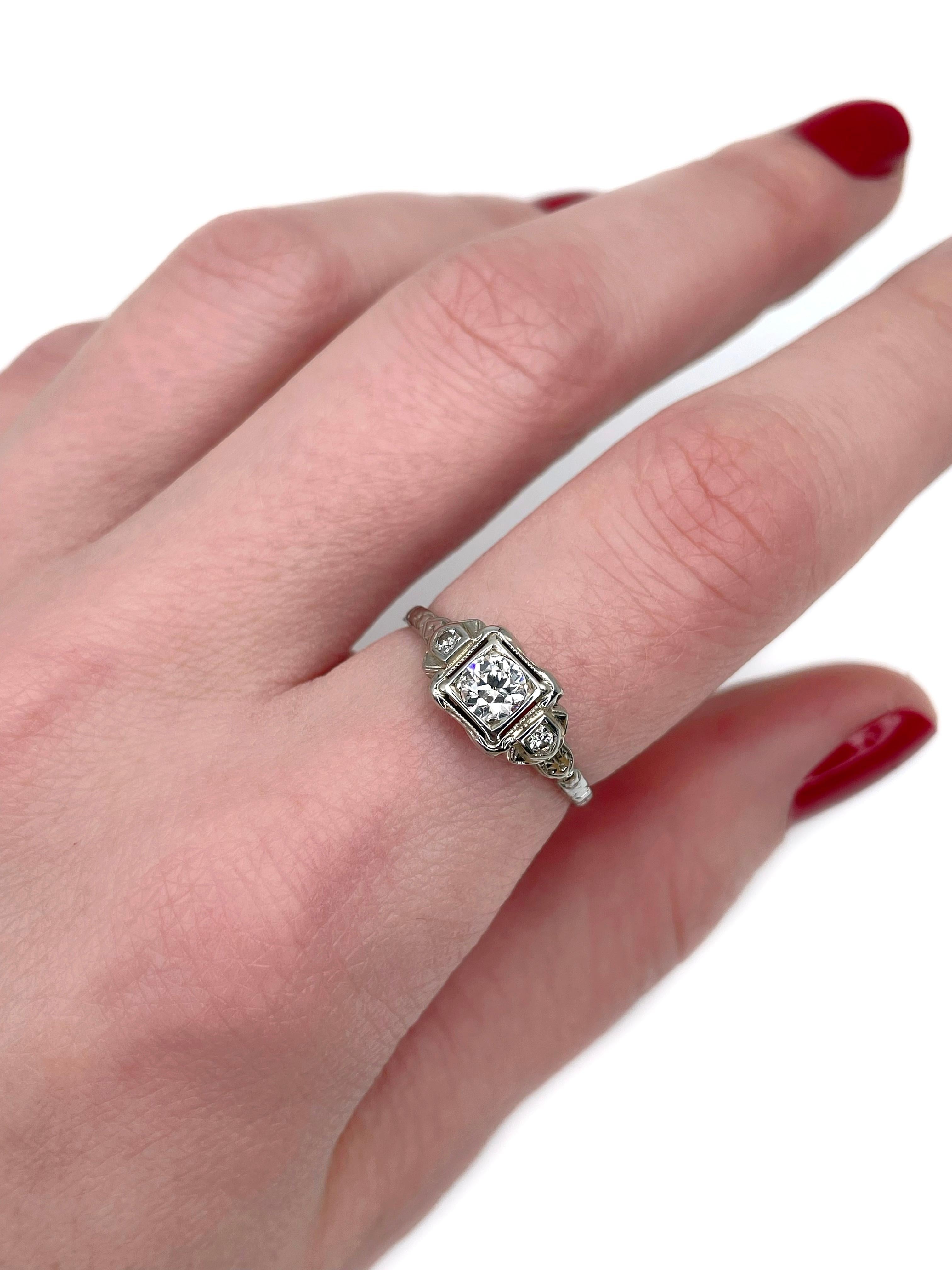This is an Art Deco three-stone ring crafted in 14K gold. Circa 1940. 

The piece features diamonds (TW 0.32ct):
- 1 diamond (round brilliant cut, 0.28ct, RW-W, VS)
- 2 diamonds (round brilliant cut, TW 0.04ct, RW-W, VS-SI)

Weight: 1.98g 
Size: