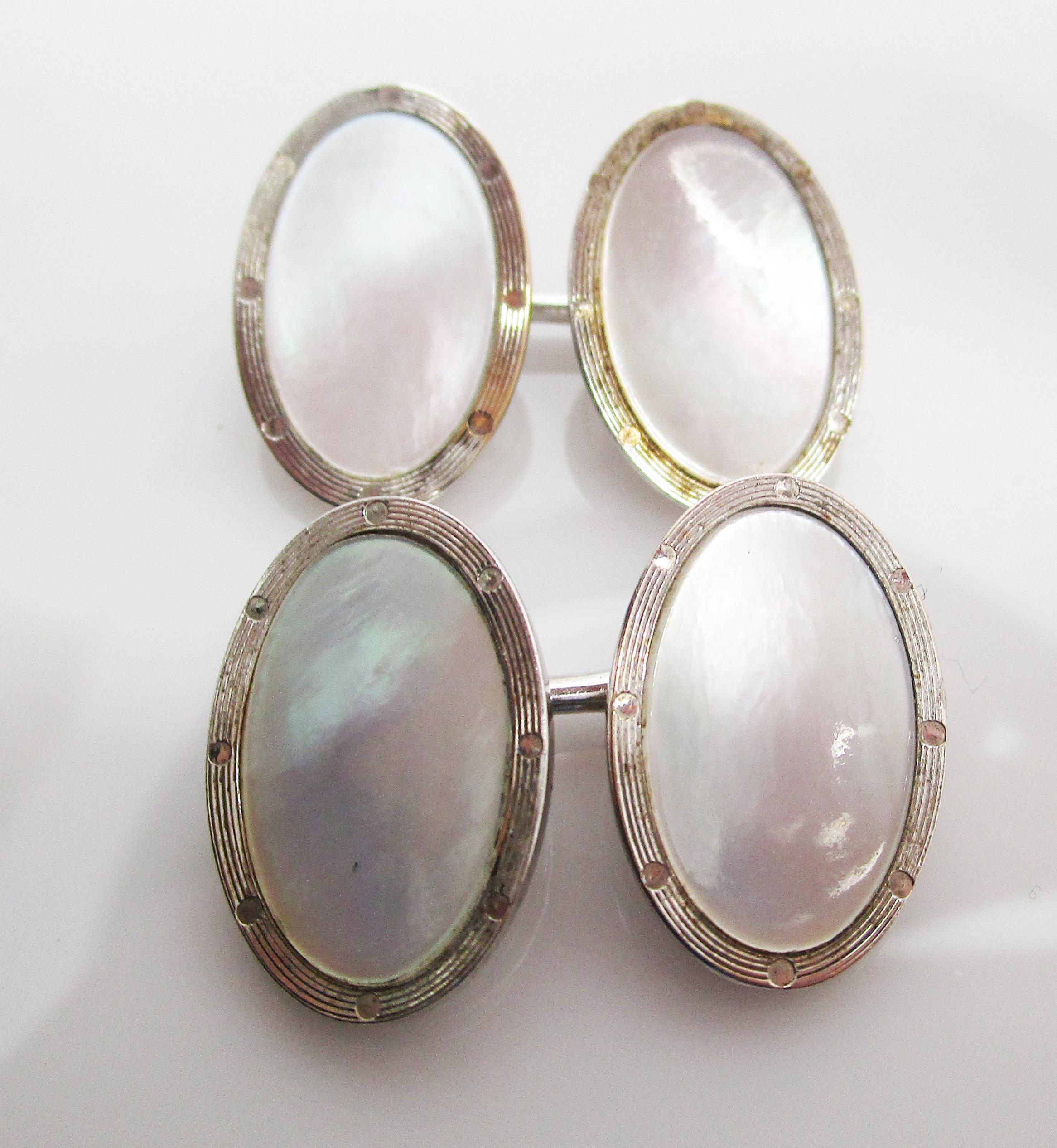 These awesome Deco cufflinks are in 14k white gold and feature elegant, iridescent mother of pearl panels! The mother of pearl panel is surrounded by a frame of engraved 14k white gold. The white on white color scheme creates an elegant,
