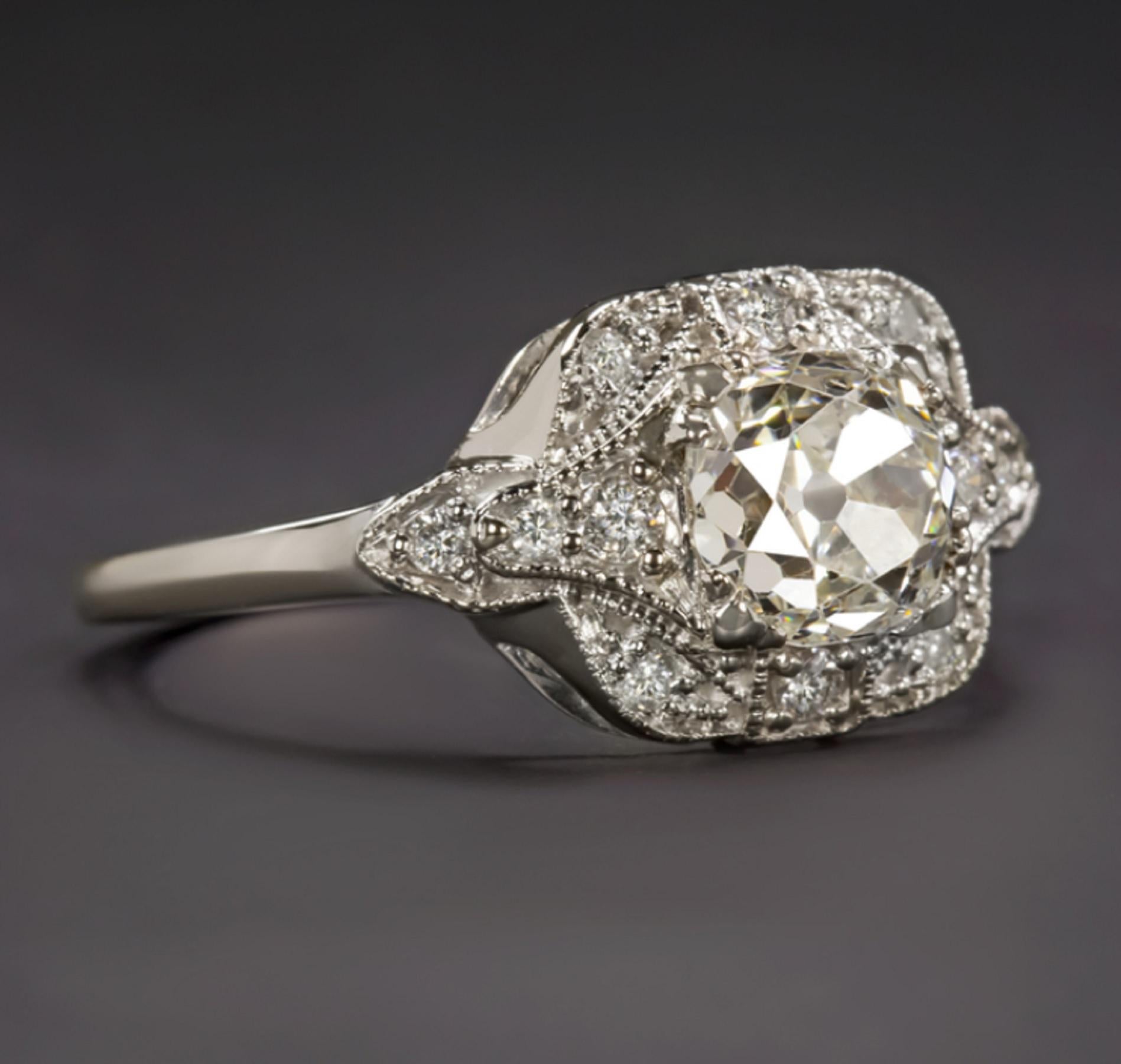A stunning vintage engagement ring features a vibrant GIA certified old mine cut diamond complemented by an elegantly designed diamond studded setting. Cut by hand well over 100 years in the past, the 1.17ct center diamond has a gorgeous chunky cut