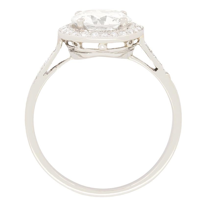 Dieser atemberaubende Diamant-Halo-Ring wurde in den wilden 20er Jahren handgefertigt. Im Mittelpunkt steht ein 1,40 Karat schwerer Diamant im Übergangsschliff, der von insgesamt 0,25 Diamanten im Acht-Schliff umgeben ist. Alle Diamanten haben die