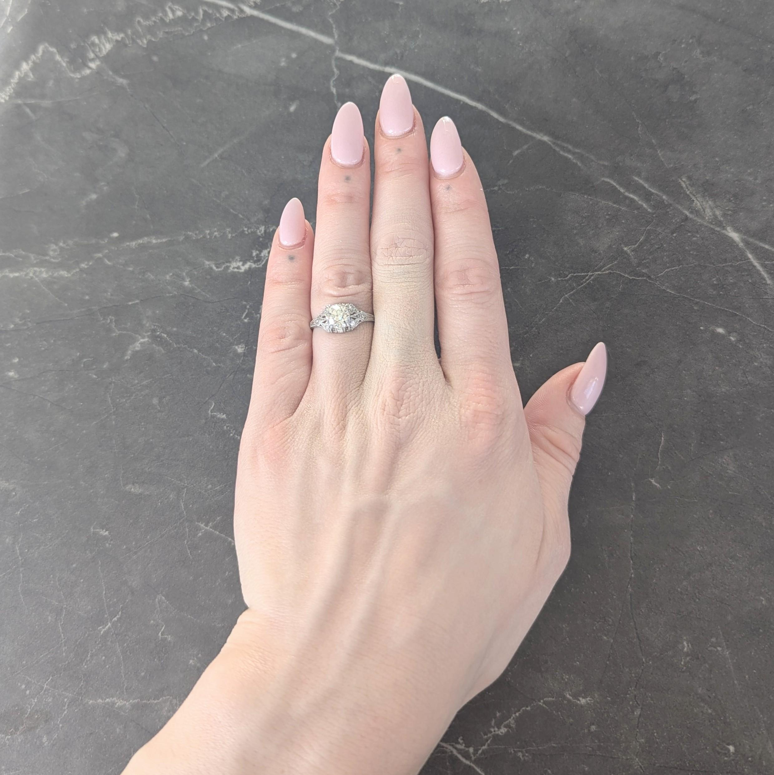 Centro de un diamante talla mina antigua de aproximadamente 1,30 quilates - color N con claridad SI1
Engastado con puntas de garra tripartitas en un marco perforado en forma de bombé con motivo foliado
Cuenta engastada con diamantes talla única con