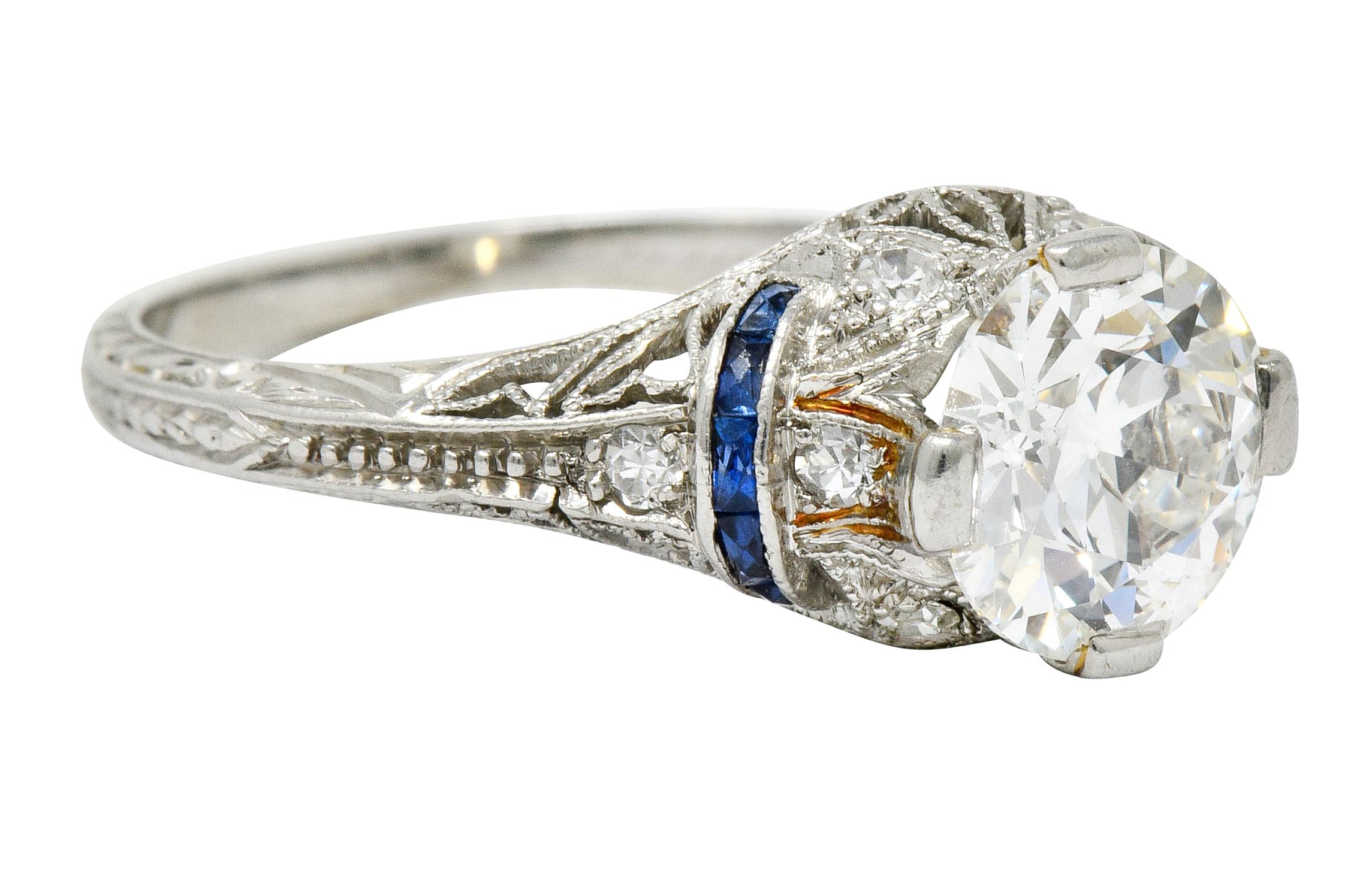 Centering an old European cut diamond weighing 1.30 carats, H in color with VS1 clarity

Flanked by two arches of calibrè cut sapphire, well-matched and royal blue in color

Accented throughout by single cut diamonds weighing approximately 0.15
