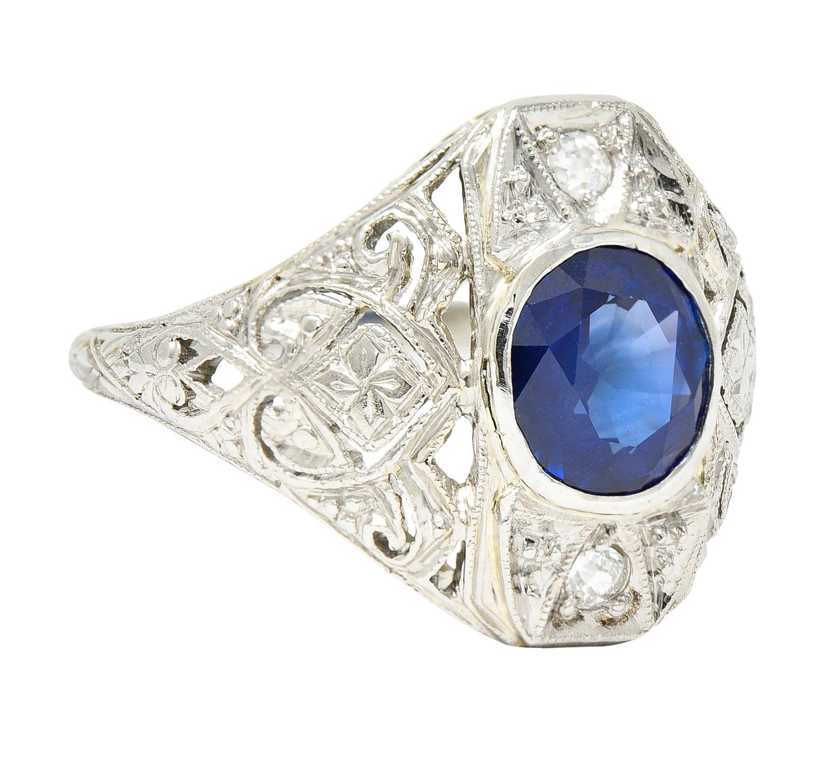 Platinum-topped mounting features a geometric and gemmed center station

With heart inspired shoulders and deeply engraved fully around the shank with foliate; white gold

Centering a bezel set oval cut sapphire weighing approximately 1.40