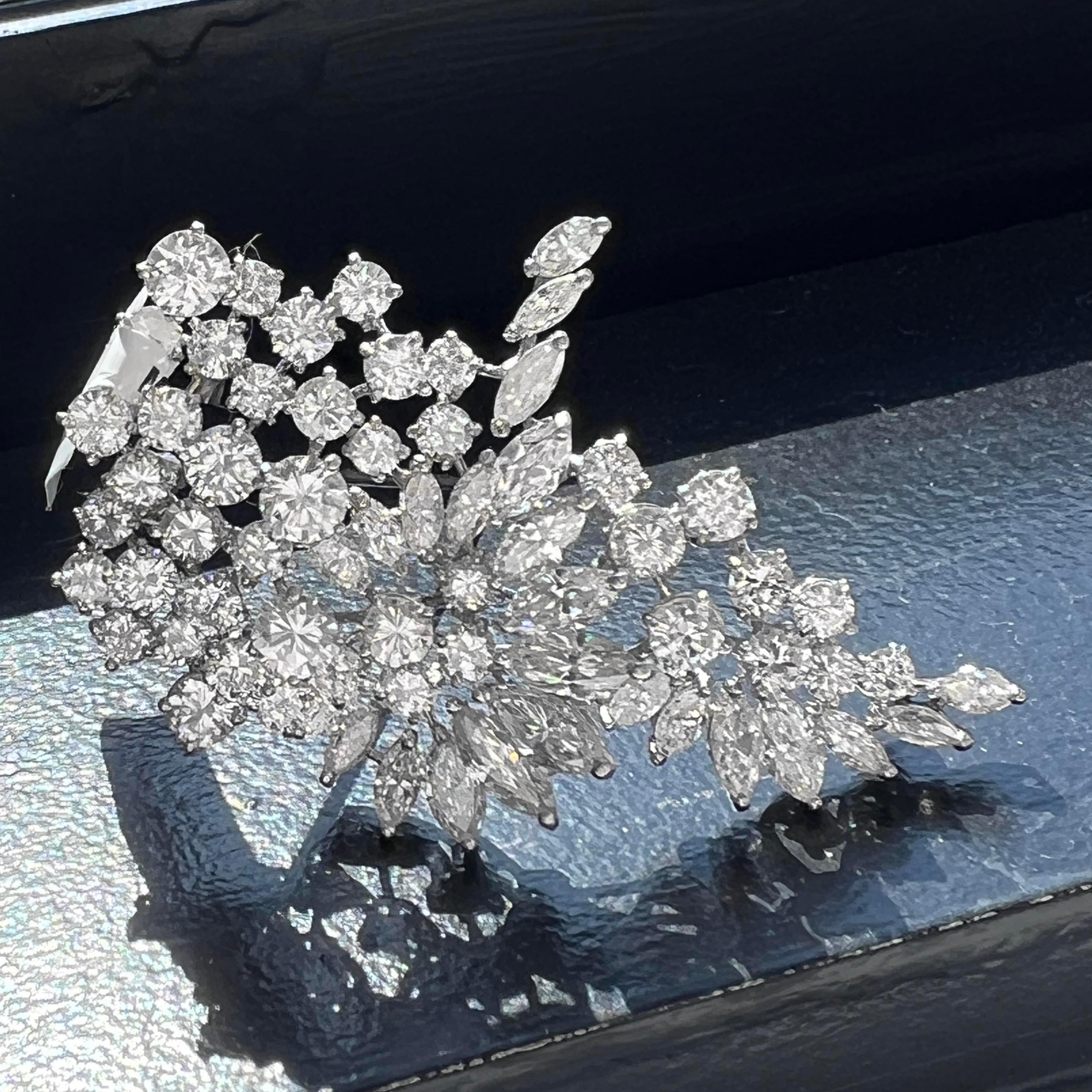 Cette exquise broche Art déco en platine, ornée d'une fleur de diamants, met en valeur 14,50 carats de diamants, façonnés avec une précision exceptionnelle. La broche présente un ensemble captivant de diamants ronds et de taille marquise, de couleur