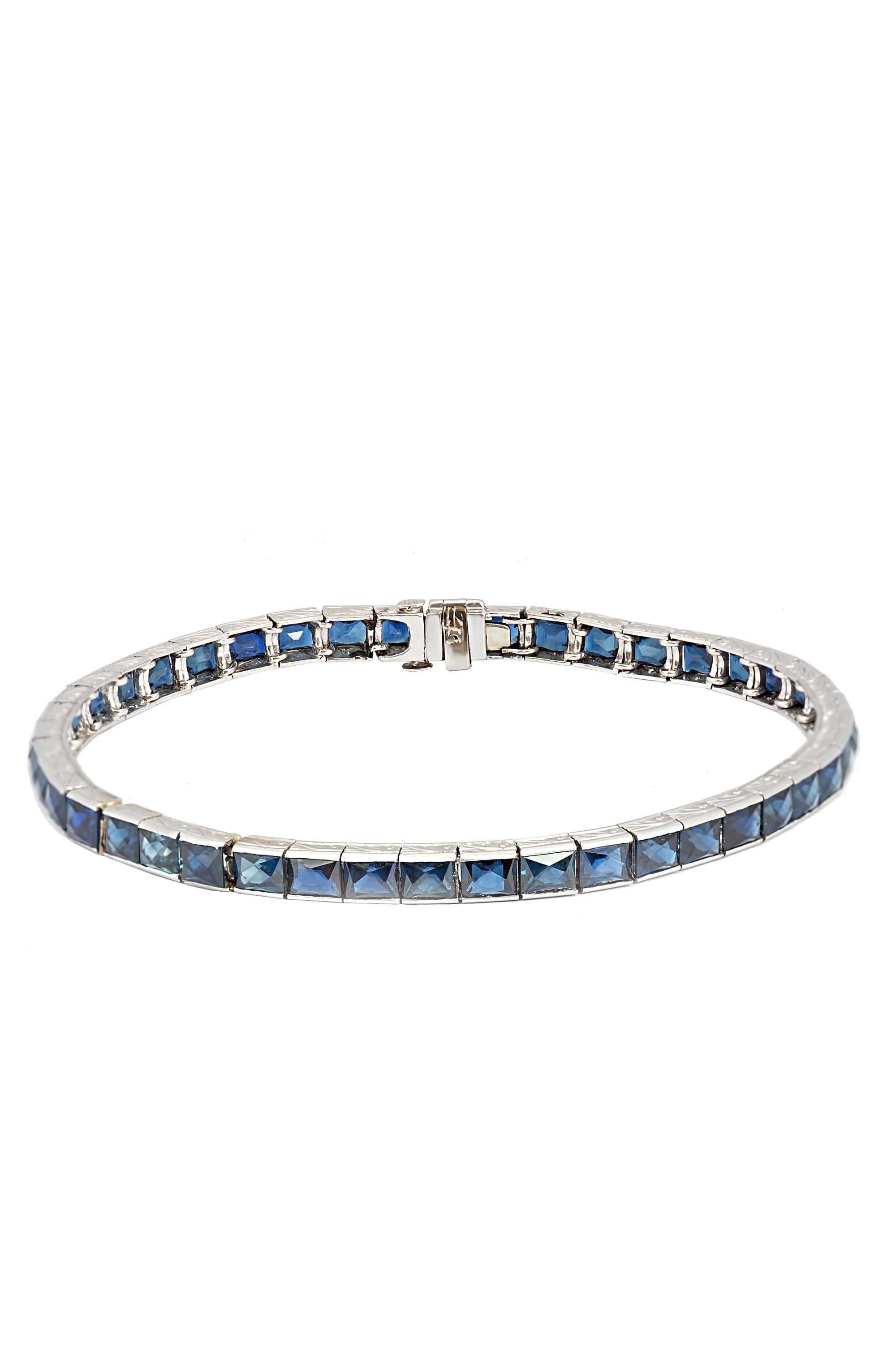 This classic Art Deco bracelet is a true work of craftsmanship, featuring a stunning line of 44 sleek French cut sapphires, totaling approximately 14.50 carats. The sapphires are beautifully set in a 14-karat white gold band, enhanced by intricate