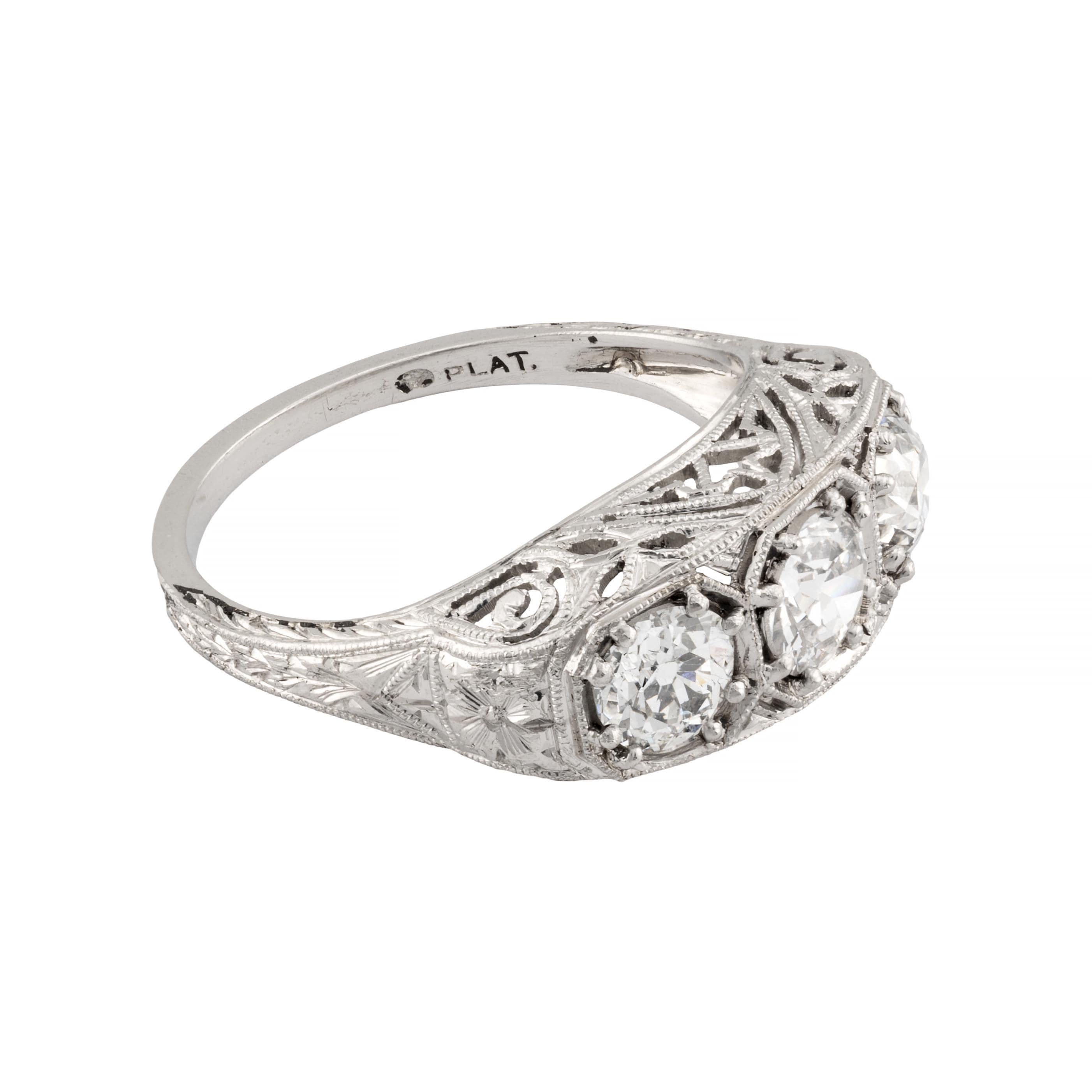 Aston Estate Jewelry Presents:

An original Art Deco period diamond three stone ring in platinum.  Boasting beautiful hand engraved detailing throughout, complemented by pierced filigree work and miligrain beading.  Centered by a 0.55 carat old