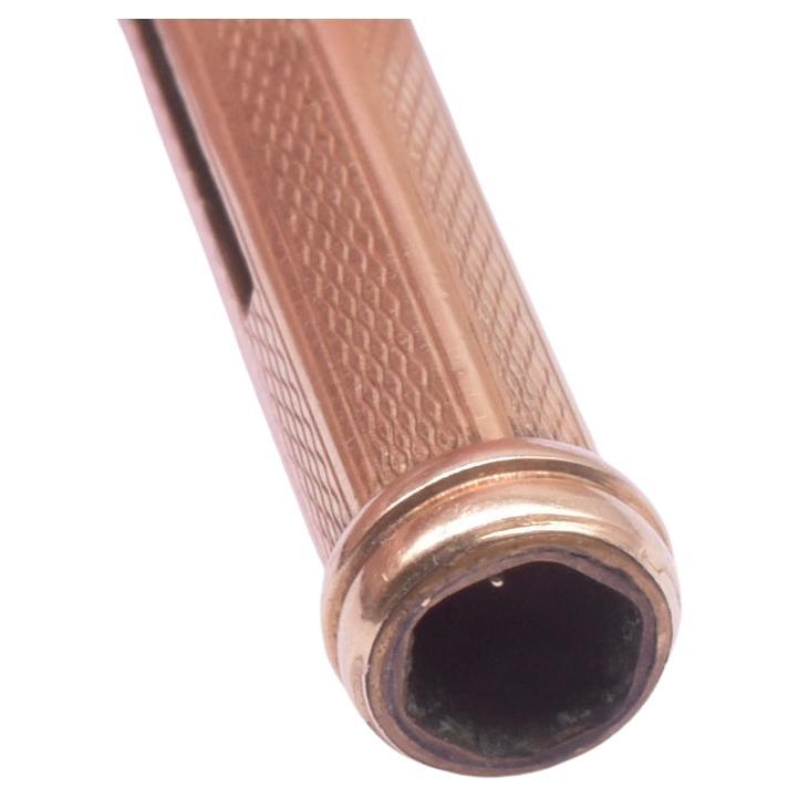 Unser 14-karätiger Zahnstocherhalter-Anhänger aus Gelbgold hat mit seiner sechseckigen Form und seiner Öffnung ein angenehmes geometrisches Aussehen. Ein leichter Druck auf das runde Stück oben am Anhänger in der Nähe des Ballens legt den Pickel