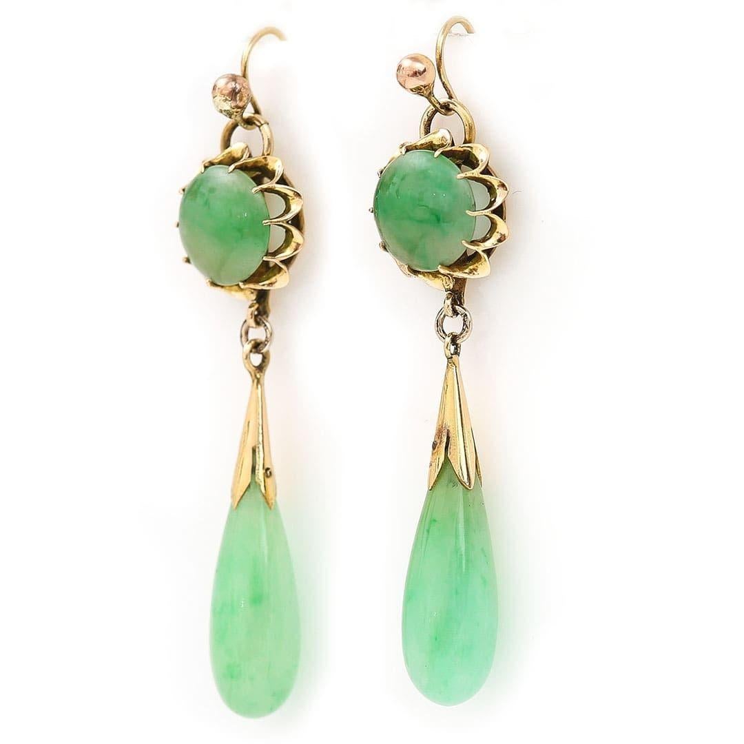 A beautiful pair of Art Deco 14ct yellow gold and celadon jade drop pendant earrings dating from circa 1930. Each drop is suspended from a prong set, polished circular piece of jade connected to a shepherd crook fitting. The larger pear shaped