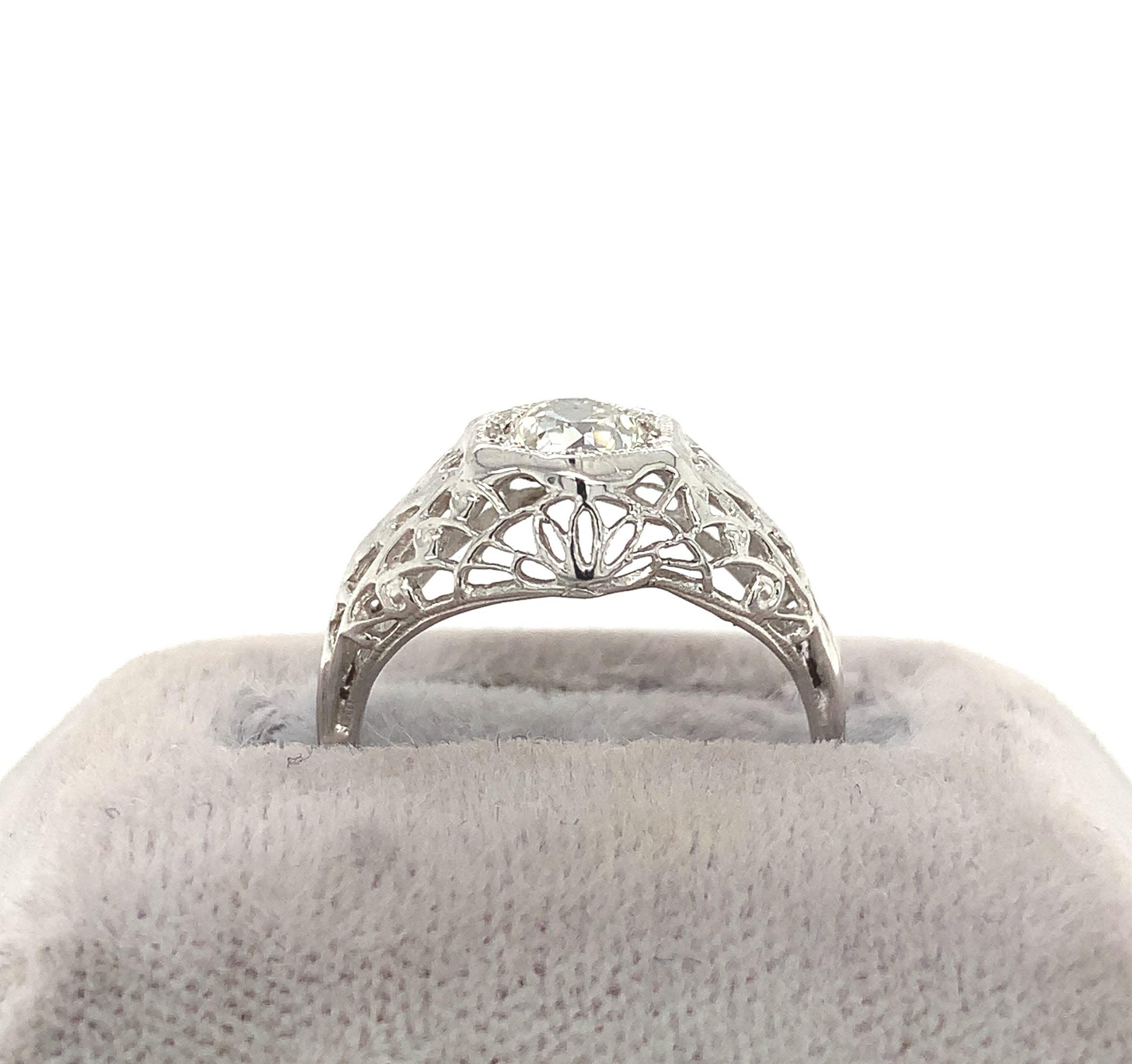 14K white gold filigree ring featuring an European cut diamond weighing about 1/2 carat. The diamond has VS2 clarity and I-J color. It measures about 4.8mm. The antique diamond is set in a delicate domed filigree mounting. The ring fits a size 5 1/2