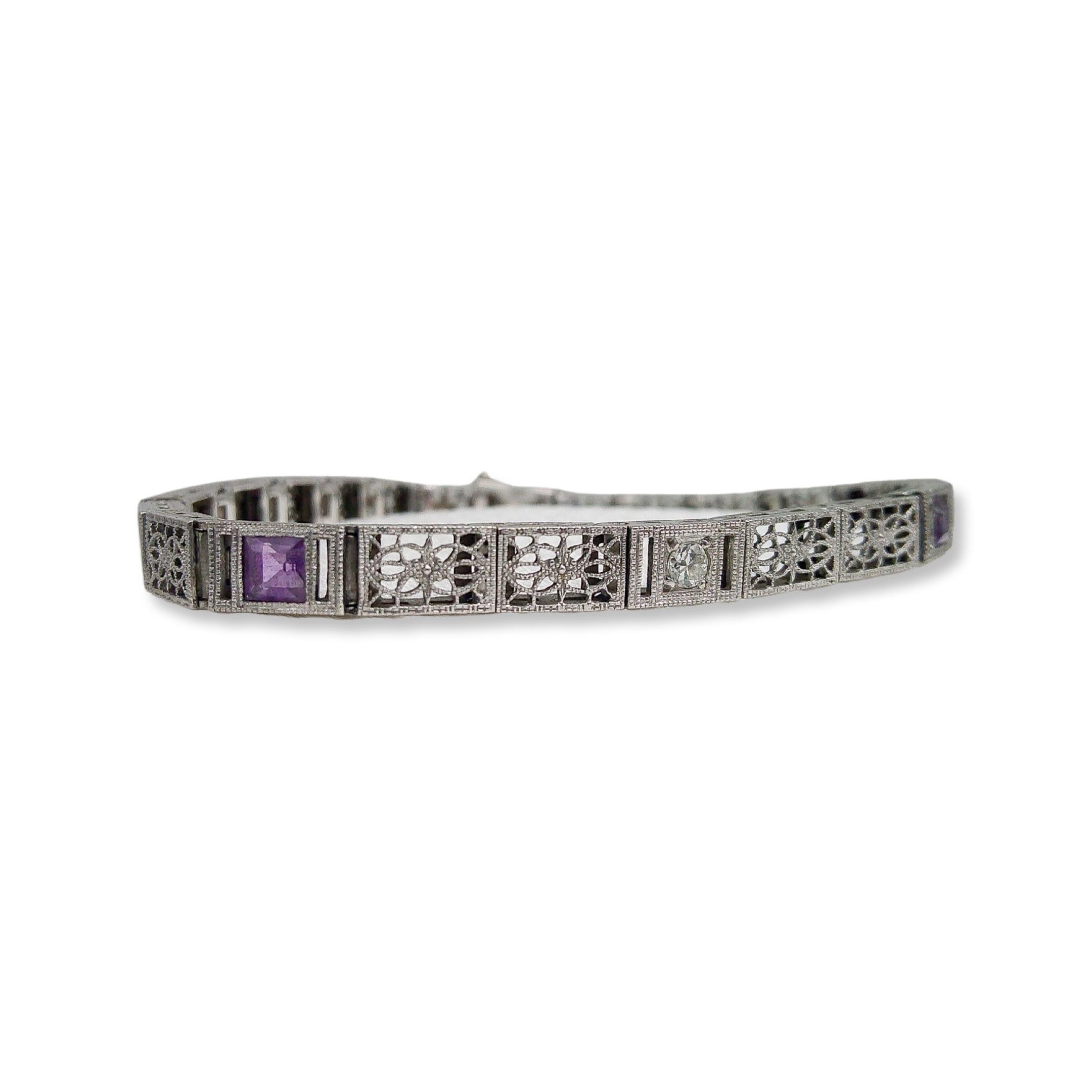 This antique piece was handcrafted sometime during the Art Deco design period (1920-1940). At the heart of this majestic bracelet sits a dazzling diamond, framed by two spellbinding amethysts. These exquisite violet gems not only add a celestial