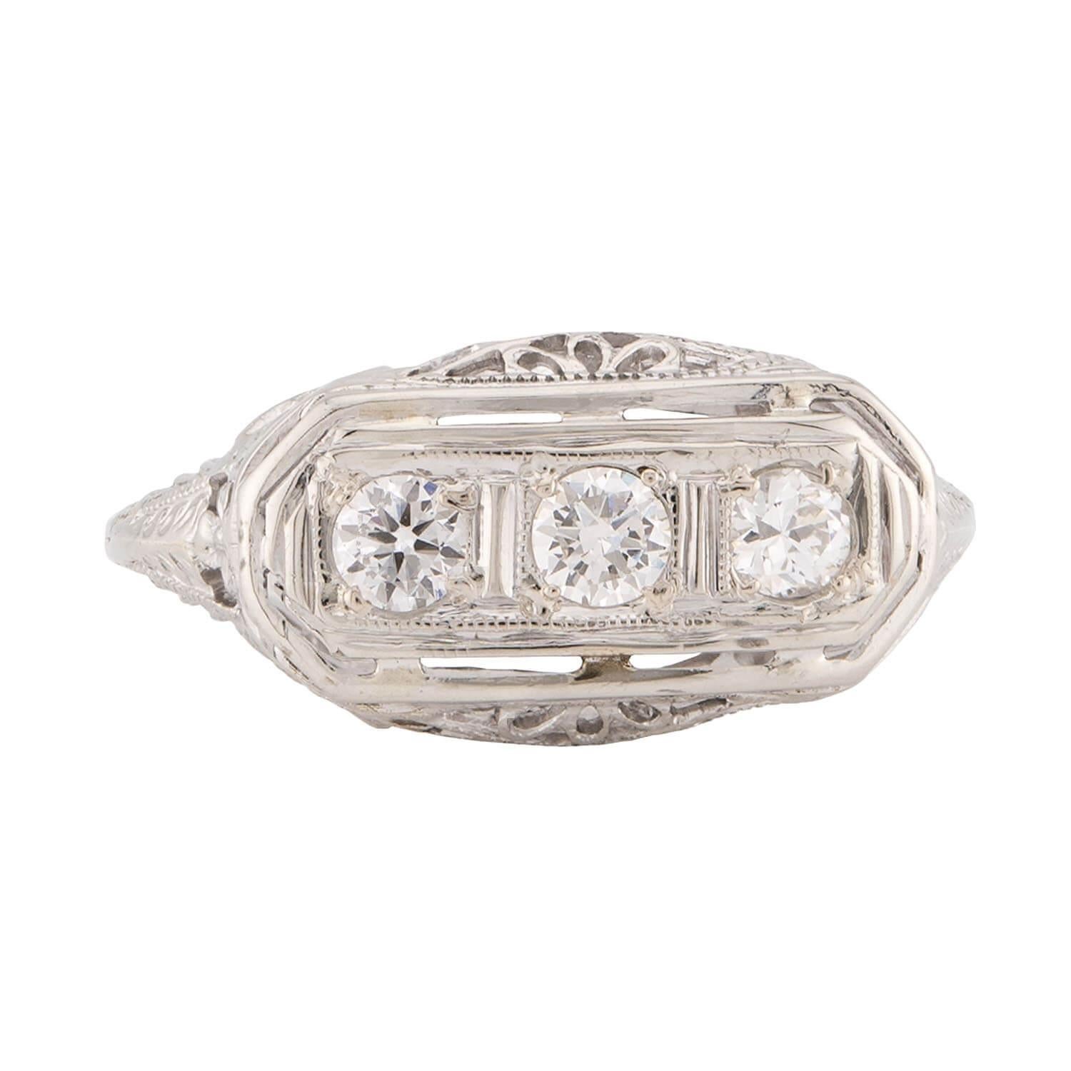 Uno splendido anello con tre pietre di diamante dell'epoca Art Deco (ca. 1920)! Realizzato in oro bianco 14 carati, questo anello presenta tre diamanti taglio vecchio Europa che corrono orizzontalmente su un centro a forma di pillola. Tutti e tre i