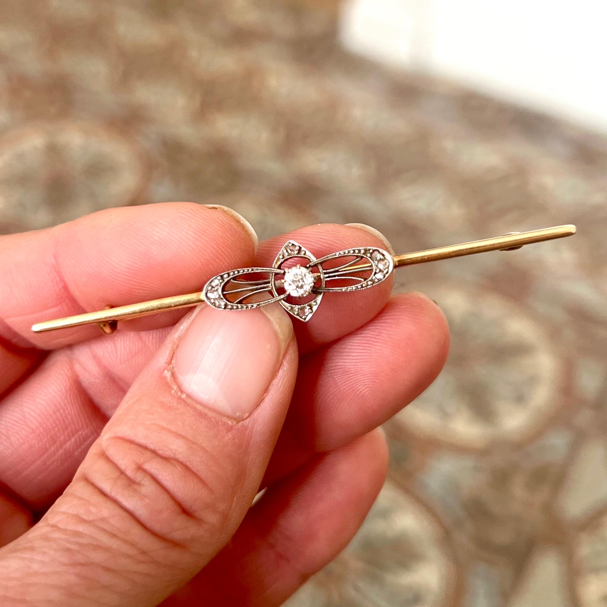This elegant Art Deco bar brooch is crafted in 14 karat yellow gold, showcasing refined geometric lines and delicate detailing characteristic of the period.

At the center, the brooch features an old mine-cut diamond weighing approximately 0.2