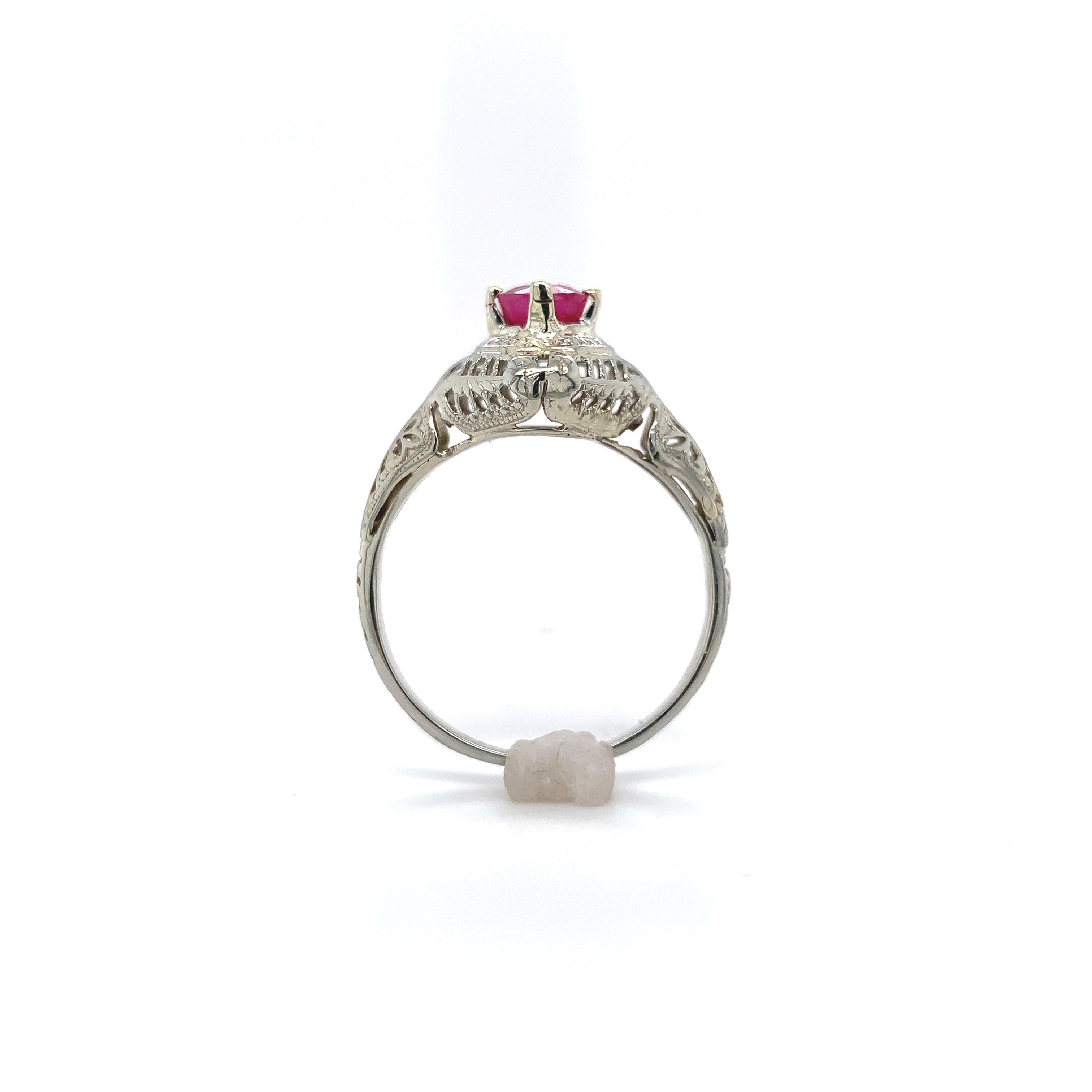 Art Deco 14K white gold filigree ruby ring. The ring features a genuine earth mined round pinkish-red ruby weighing .66cts. The ruby measures about 4.7mm. The ring has all new prongs. The ring fits a size 7 finger. It weighs 1.62dwt and dates from