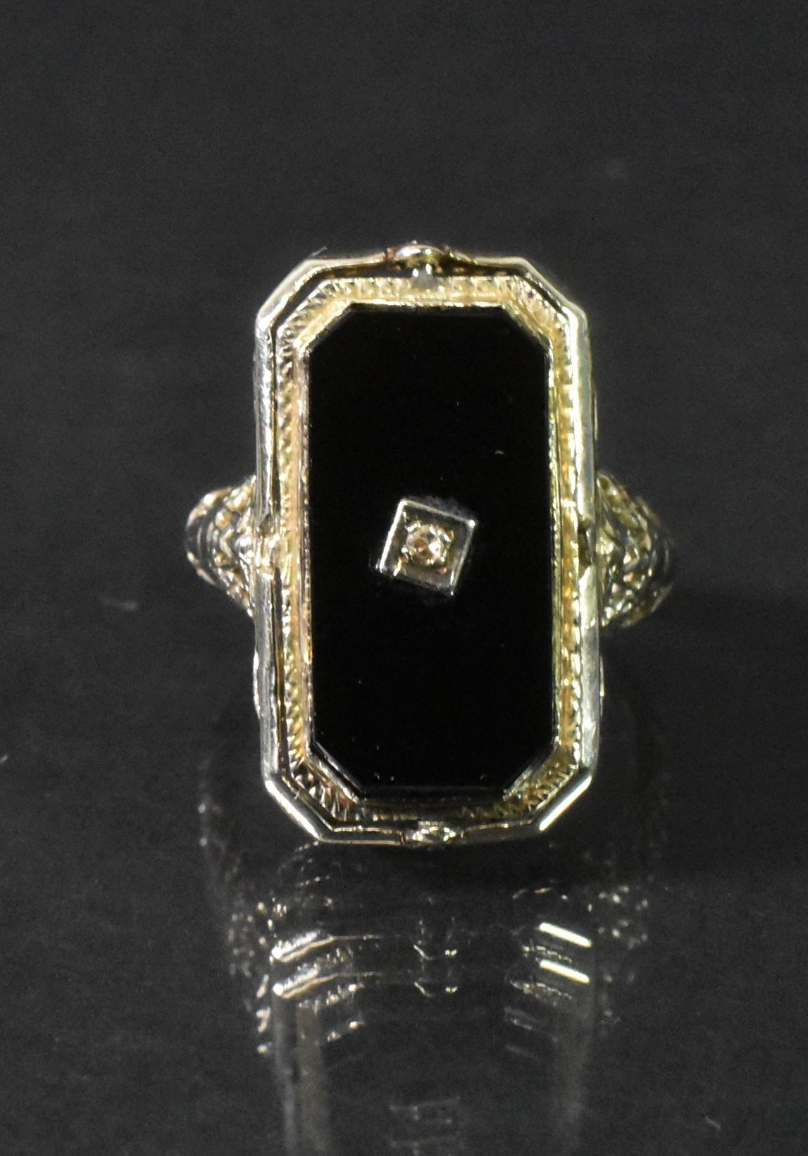 This beautiful onyx and cameo flip ring is from the 1920's-1930's and made of white 14k gold. This piece is comprised of 2 individual faces which flip, making a ring that can be worn 2 different ways. One side is a black onyx rectangle with a center