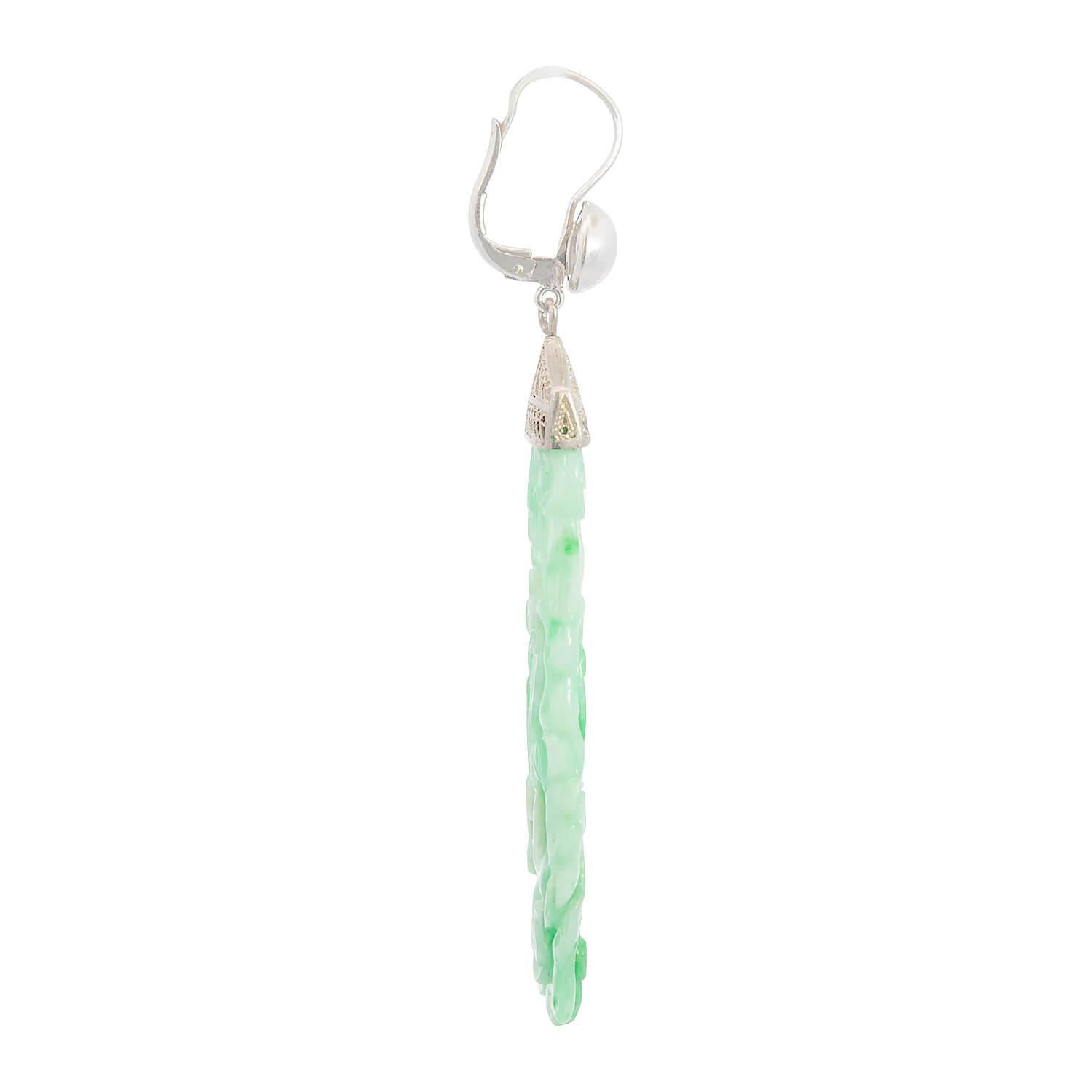 ¡Un hermoso par de pendientes de jade tallado de la época Art Déco (ca1920s)! Elaborados en oro blanco de 14 quilates y platino, estos pendientes presentan una pieza larga y rectangular de jade. El jade no está tratado y presenta intrincadas tallas