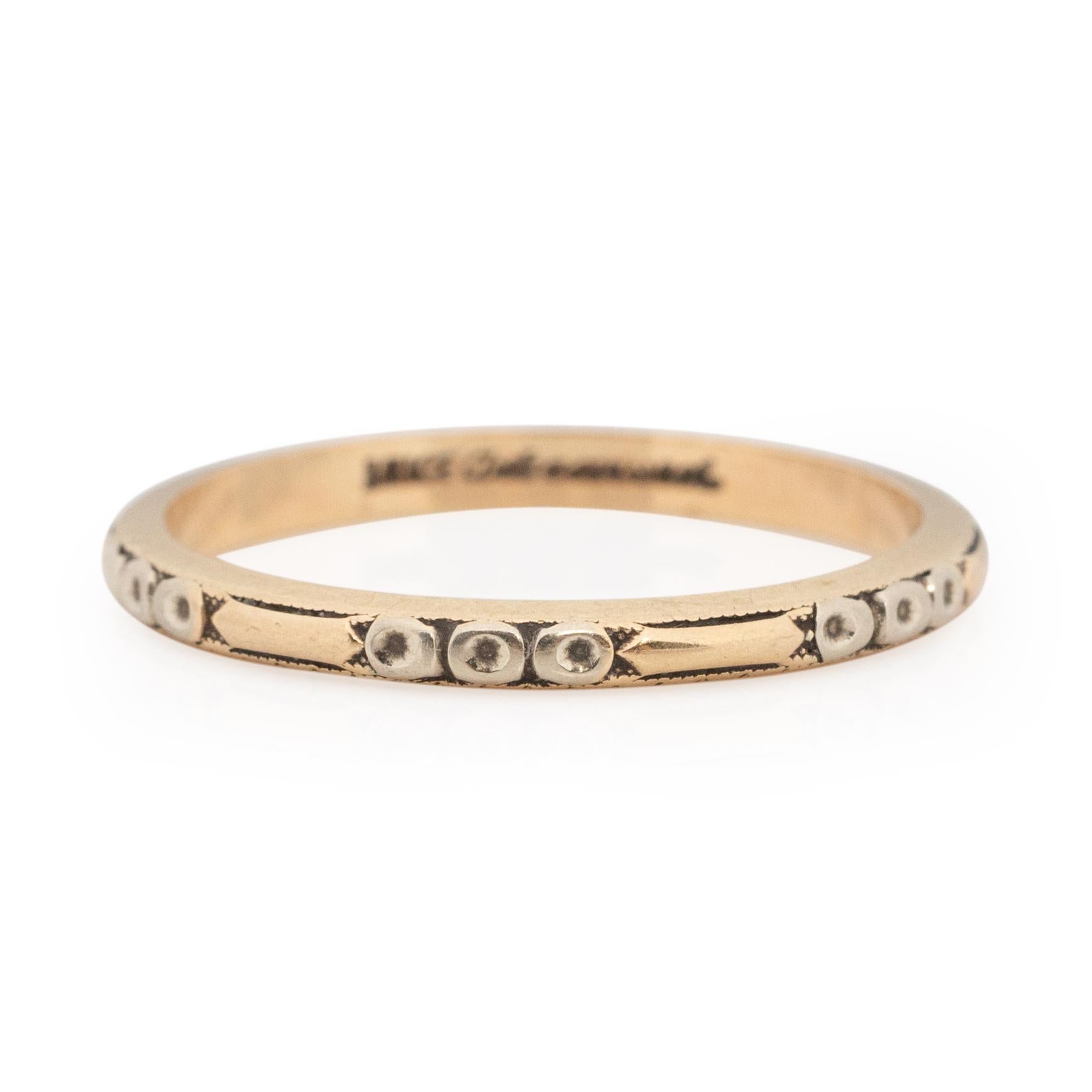 This art deco piece is in outstanding condition for its age. Crafted in 14k gold, the rings base is yellow gold. The repeating circle and line design has a pop of white gold in the circle part of the design. This thin band is beautifully made, the