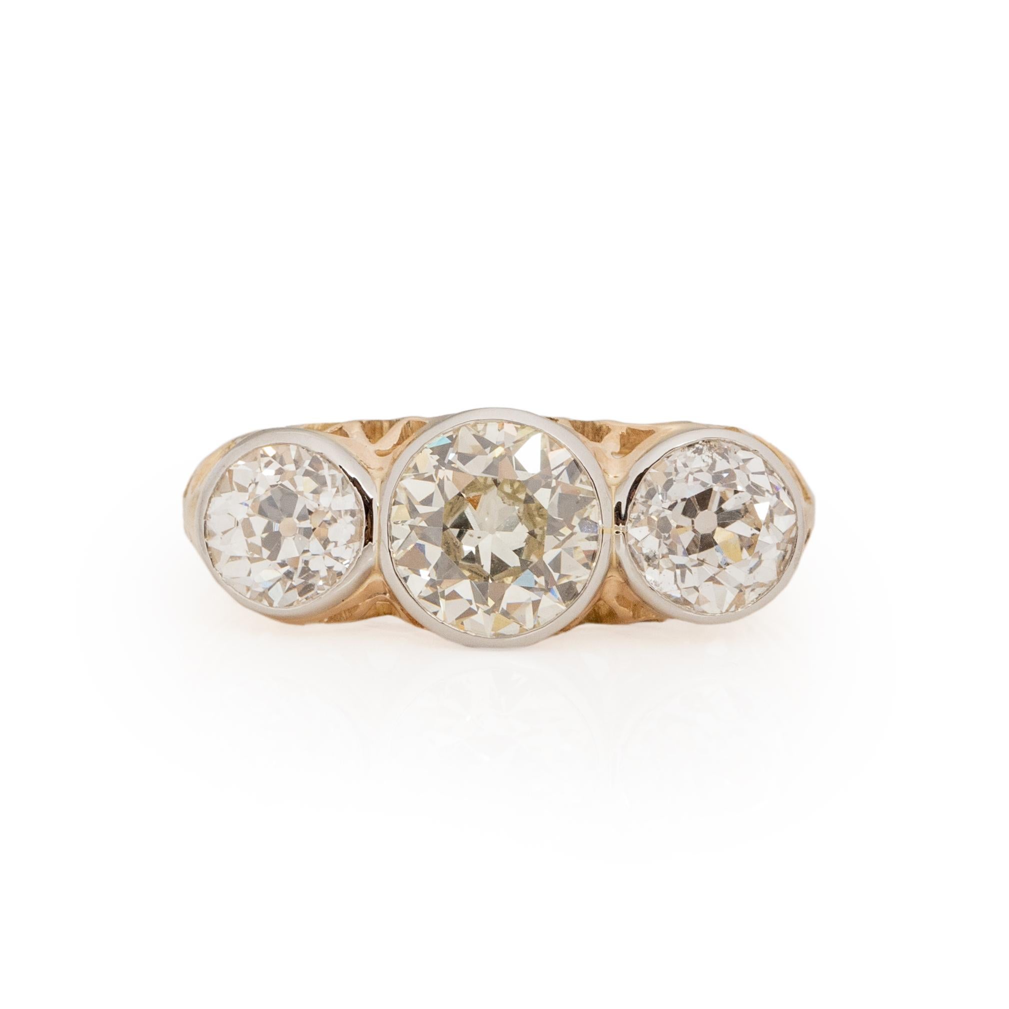 This three stone beauty has exceptional details. Crafted in 14K yellow gold, and 14K white gold for the bezel setting, the two tone look is a subtle, unique look that compliments the overall design effortlessly. The yellow gold base has a delicately