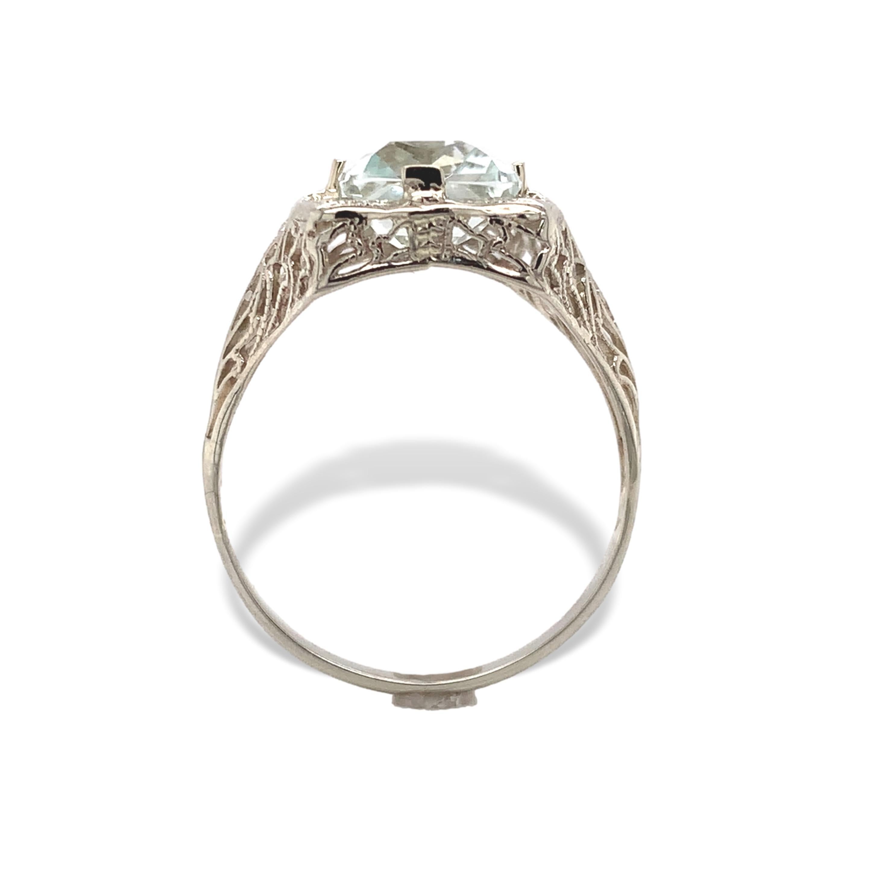 14K white gold aquamarine filigree ring. The antique rectangular brilliant cut aquamarine is a very pale icy color. It is the original stone that has been carefully repolished. The aquamarine measures about 9.5mm x 7.5mm. The ring fits a size 8.25