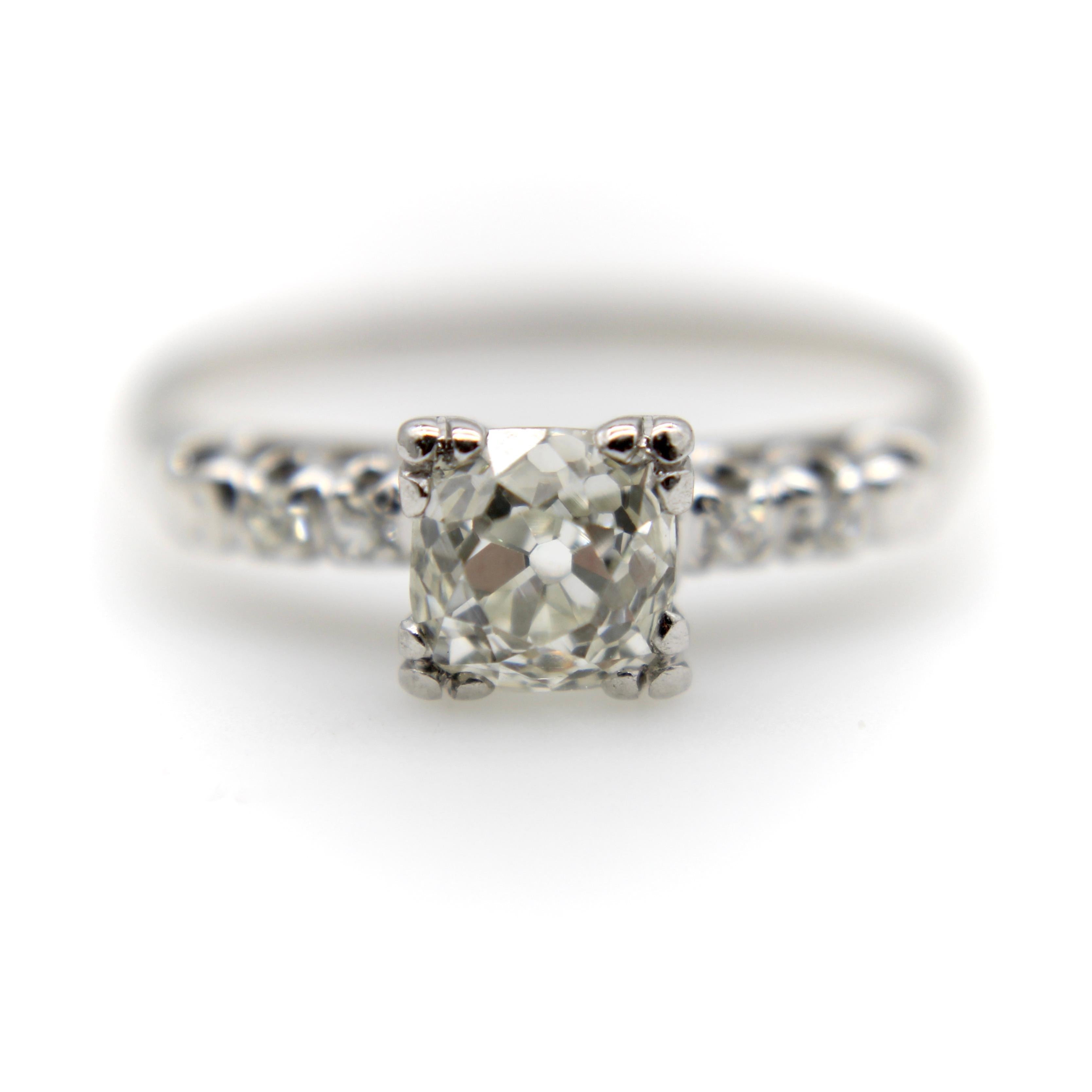 This 14k white gold Art Deco ring features a diamond that is older than the ring. The antique Victorian era diamond is Old Mine Cut, and also cushion cut, square in shape with soft rounded corners. The diamond is held in place by three prongs on