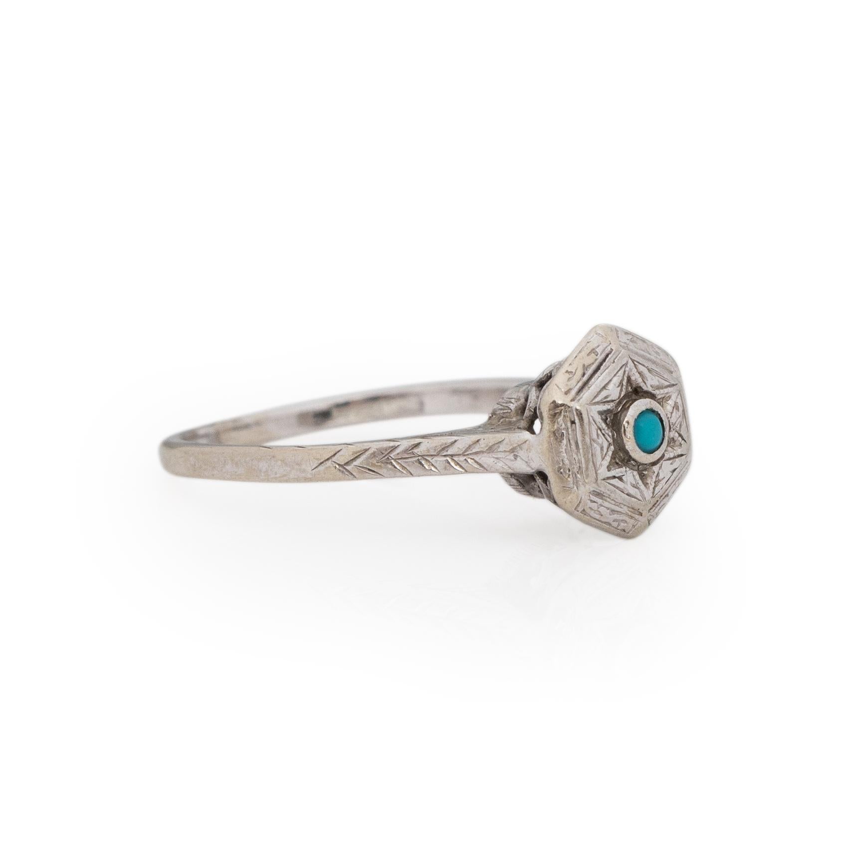 Here we have a petite Art Deco beauty. Crafted in 14K white gold, a small sky blue turquoise cabochon sits in the middle of a hexagonal shaped center with a star engraving surrounding it. Around the star center is a carved filigree border leading