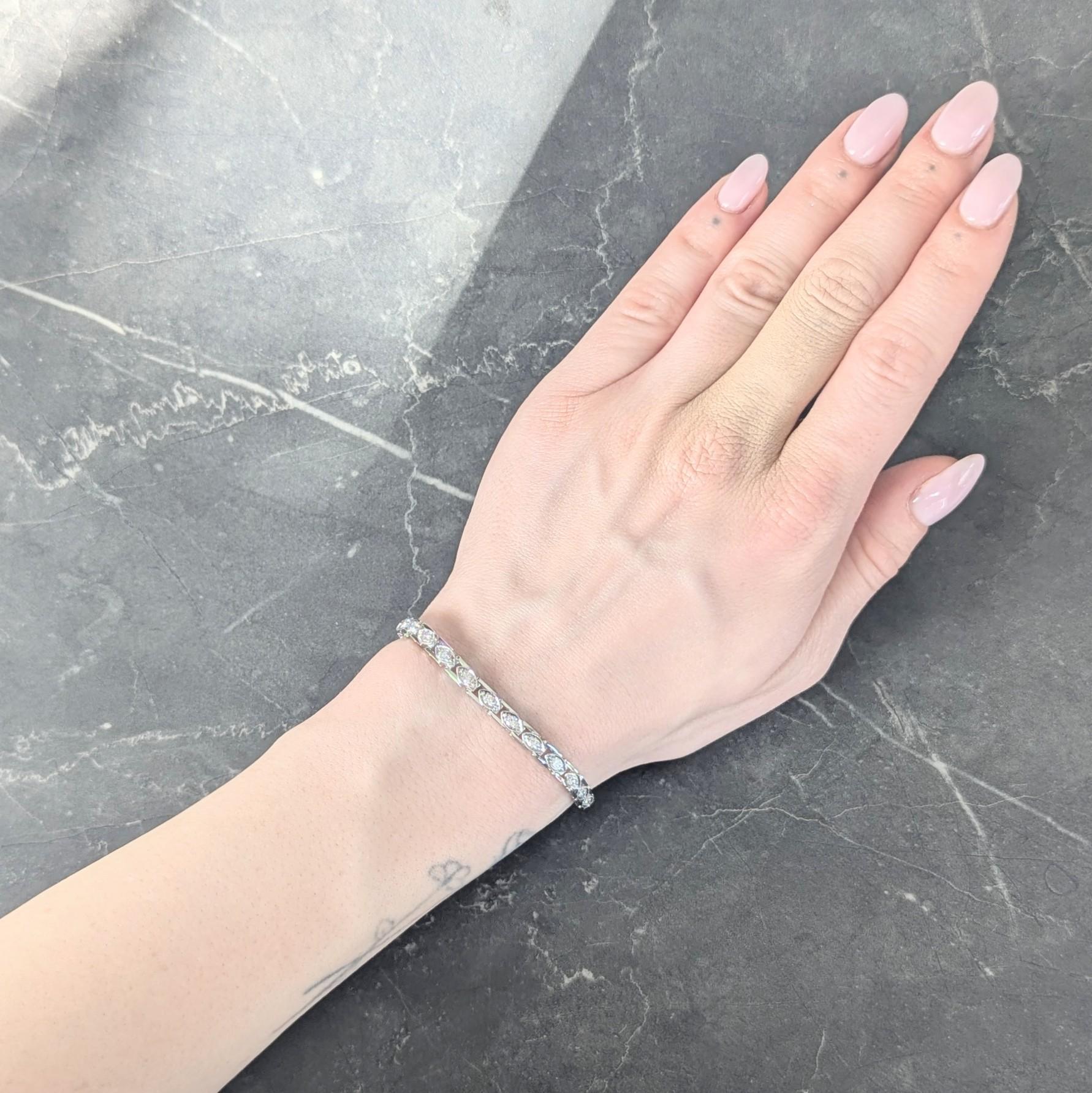 Comprised of hinged ladder links topped with marquise shaped forms
Each centering a bead set transitional cut diamond
With additional diamonds bead set on clasp
Weighing approximately 1.50 carats total
G/H color with VS2 clarity
Accented by milgrain