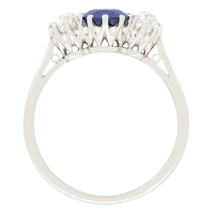 An intense blue sapphire sits between two glittering old cut diamonds in this Art Deco trilogy ring. The 1.50 carat sapphire’s vibrant colour is completely natural and unheated. The old cut diamonds weigh 0.25 carat a piece, with a colour grading