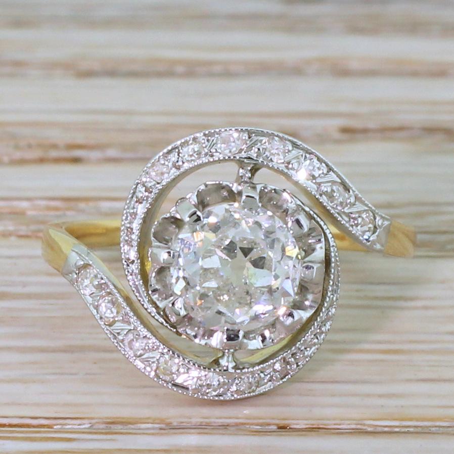 A wondrous whirlwind of a ring. This stunning tourbillon ring features a large, bright old mine cut diamond set in an open, eight-claw setting that sits nice and low to the finger. A total of sixteen eight-cuts are set in the slim and tapering