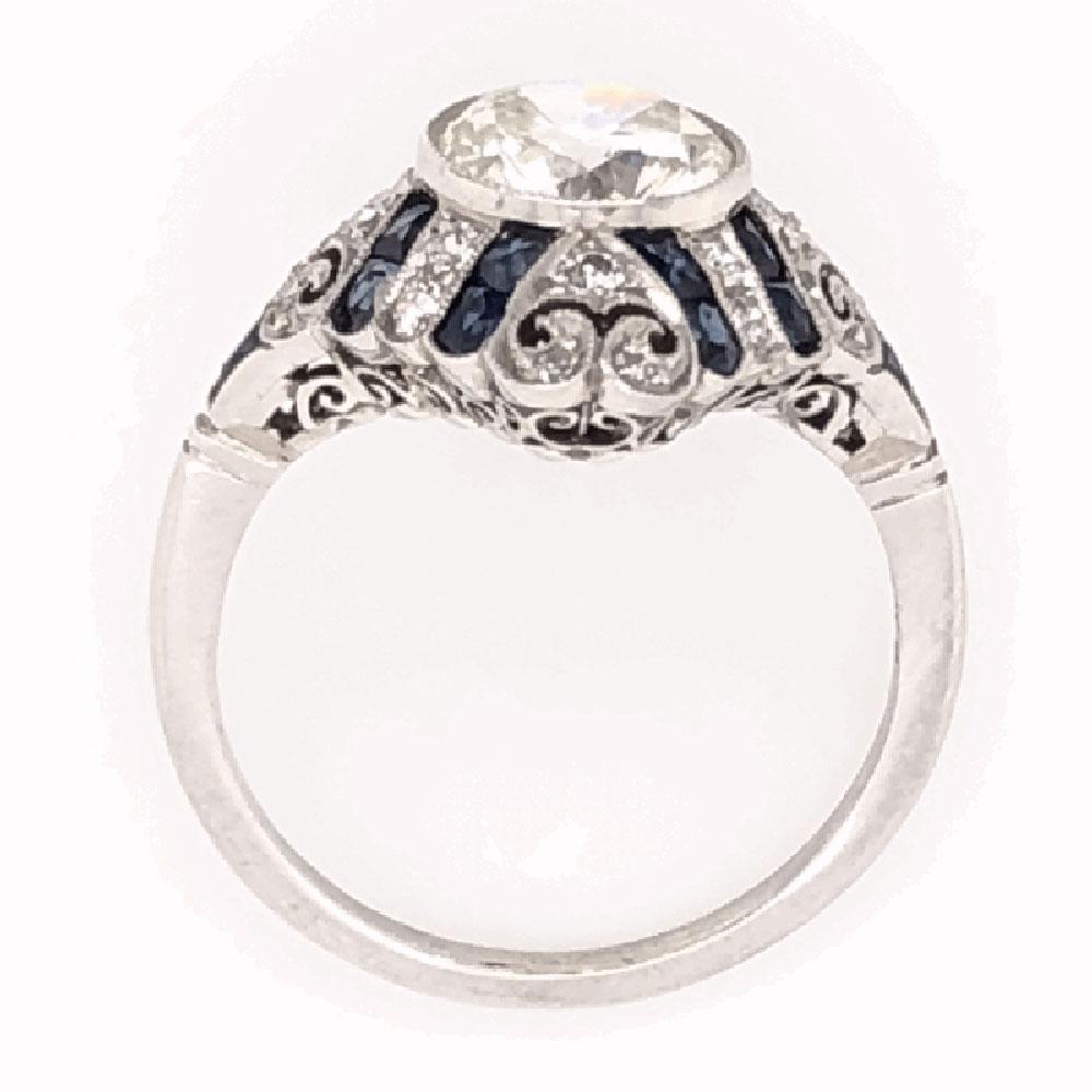 Simply Beautiful, Elegant & finely detailed Art Deco style Platinum Ring center set with a securely nestled Antique Round cut Diamond, weighing approx. 1.52 total Carat weight, enhanced with Blue Sapphires approx. 1.21 total Carat weight. Ring size