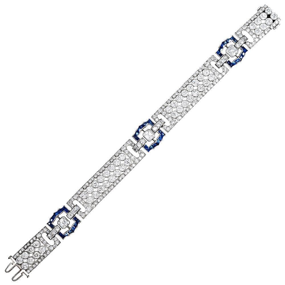 An outstanding and unique original art deco creation with striking style elements and glamourous character, the bracelet is set with an impressive 231 brilliant white diamonds highlighted by intense blue sapphire accents. The sapphire-set links
