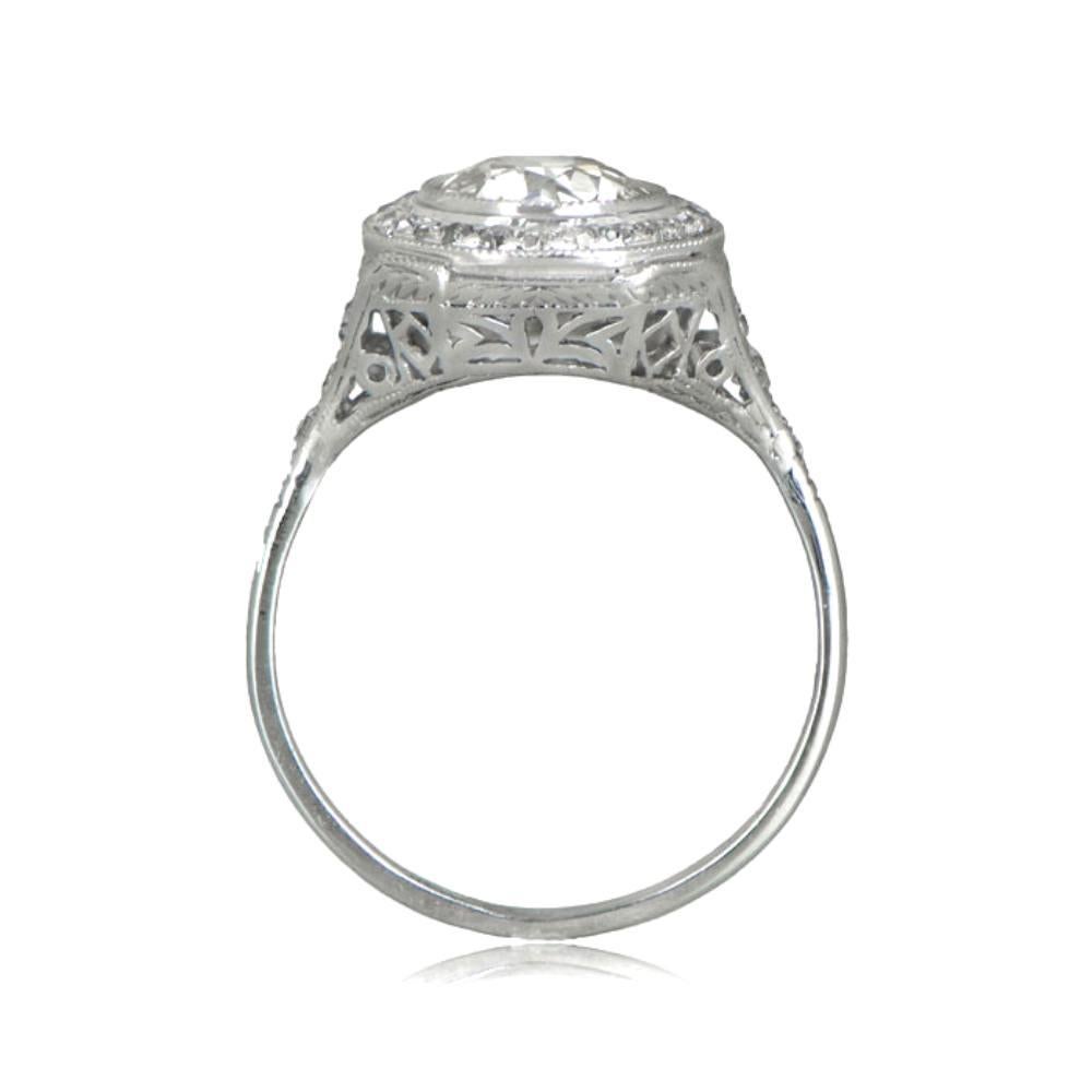 An exquisite Art Deco Era engagement ring with a halo of diamonds encircling the center old European cut diamond. The handcrafted platinum setting features delicate engravings and openwork. The center diamond is 1.55 carats, I color, and VS1